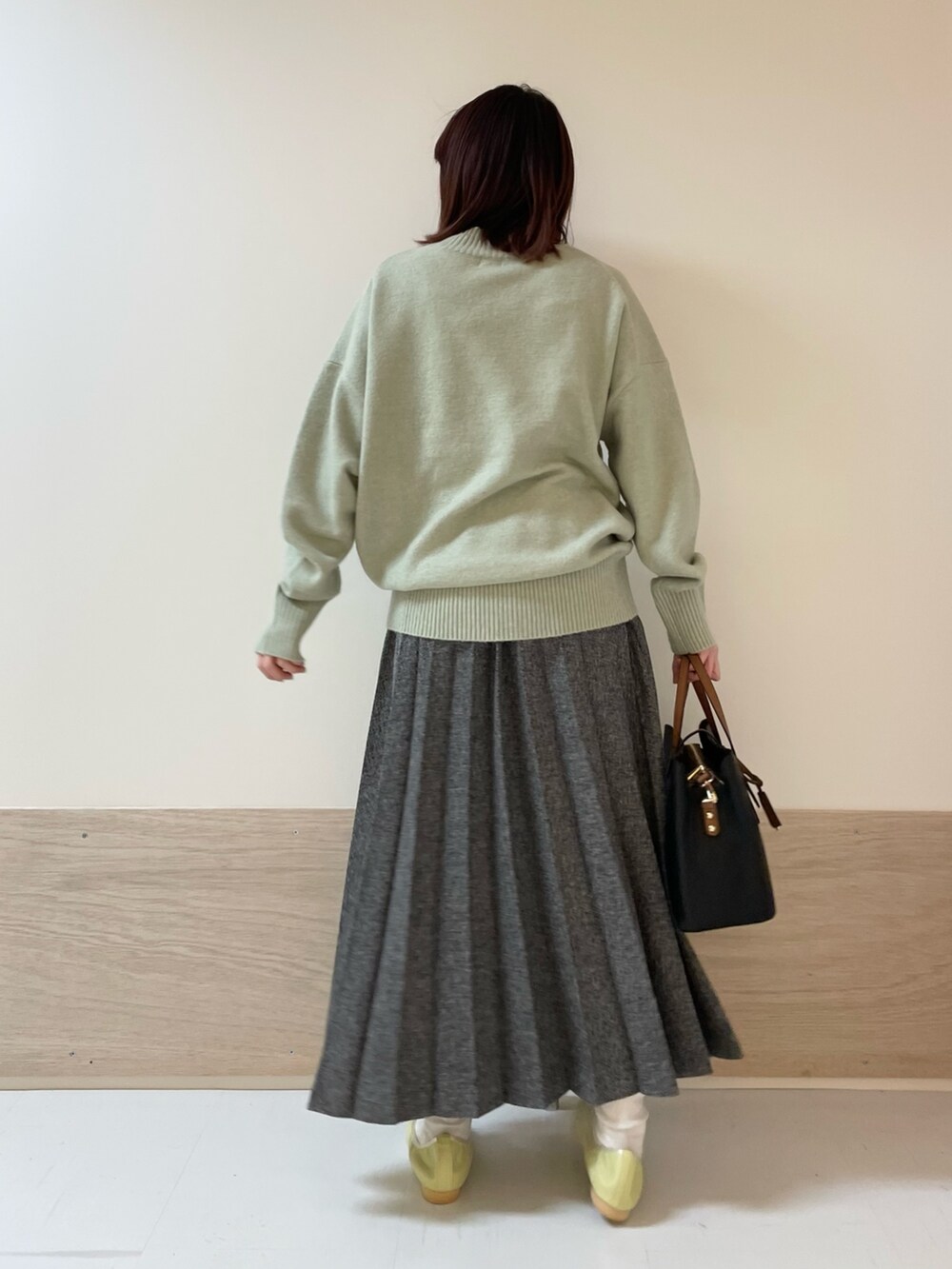 グリーン系のニット/セーター、イエロー系のバレエシューズ、ブルー系のスカートを着用したレディースの冬コーディネートの7枚目の写真
