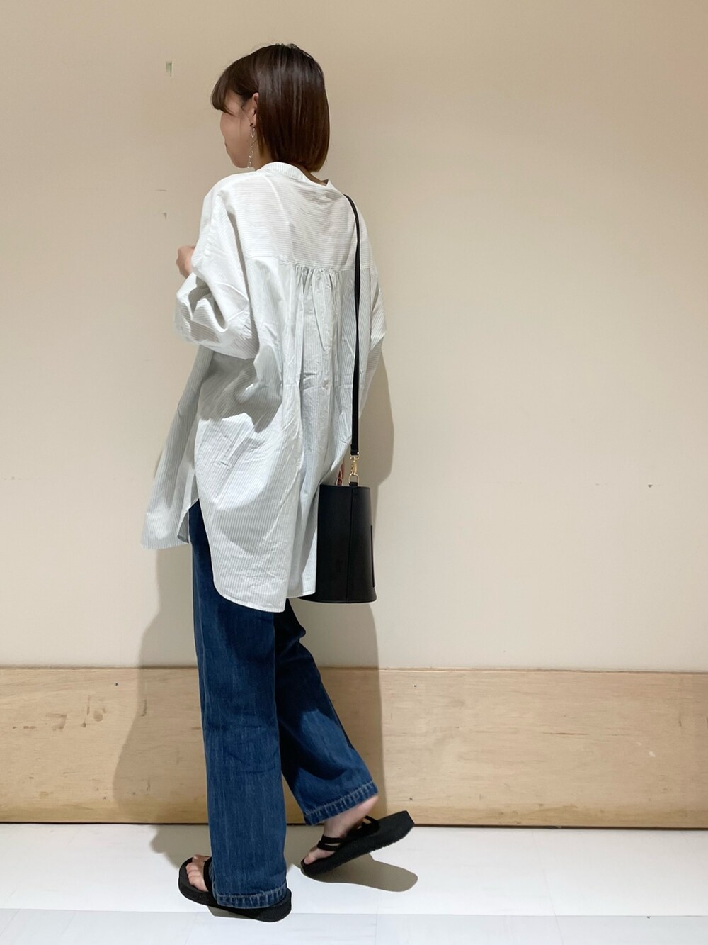 グリーン系のシャツ/ブラウス、ブルー系のデニムパンツ、ブラック系のサンダルを着用したレディースの夏コーディネートの5枚目の写真