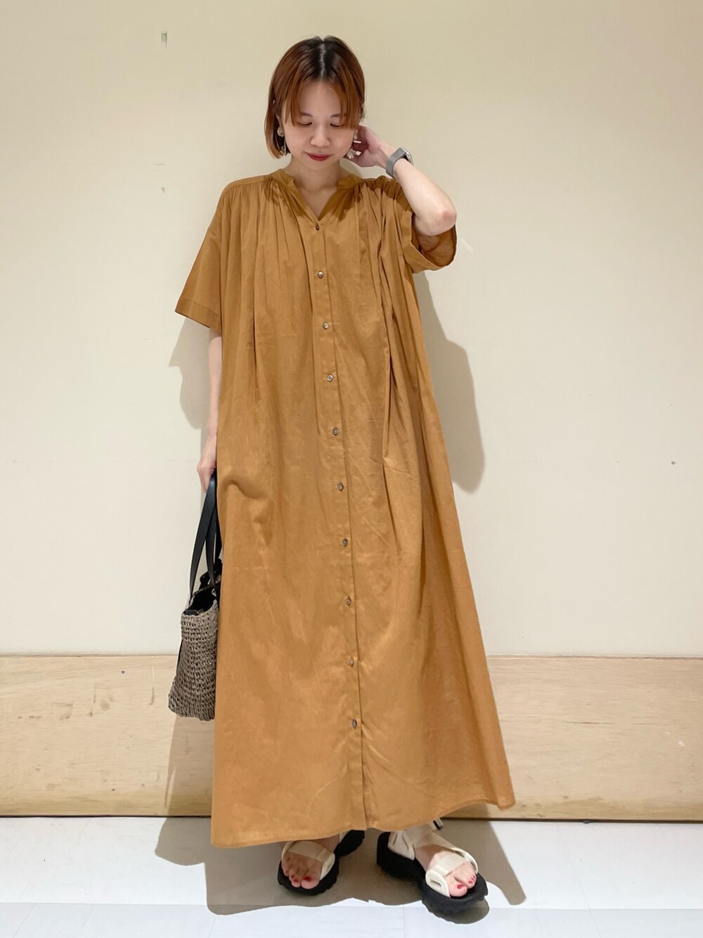 ブラウン系のワンピース、ホワイト系のサンダル、グレー系のトートバッグを着用したレディースの夏コーディネートの2枚目の写真