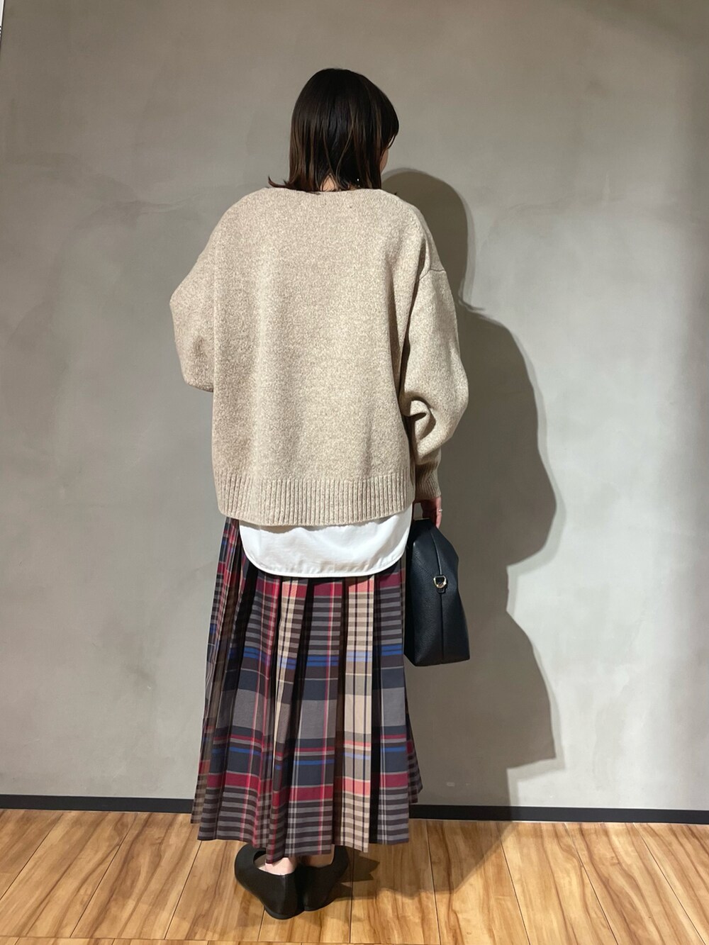 ベージュ系のニット/セーター、ピンク系のスカート、ブラック系のパンプスを着用したレディースの秋コーディネートの3枚目の写真