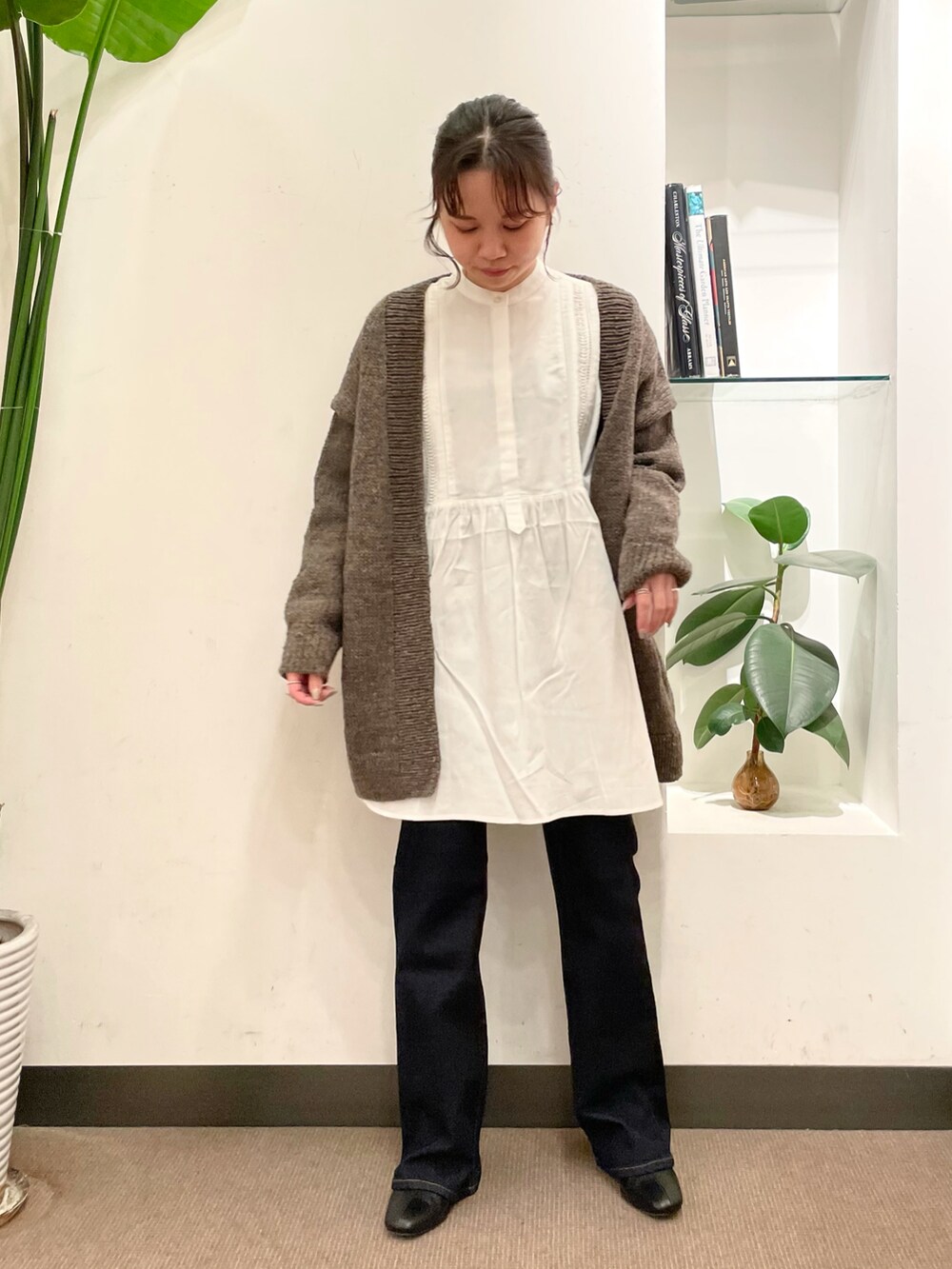 グレー系のカーディガン/ボレロ、ホワイト系のシャツ/ブラウス、ブルー系のデニムパンツを着用したレディースの秋コーディネートの3枚目の写真