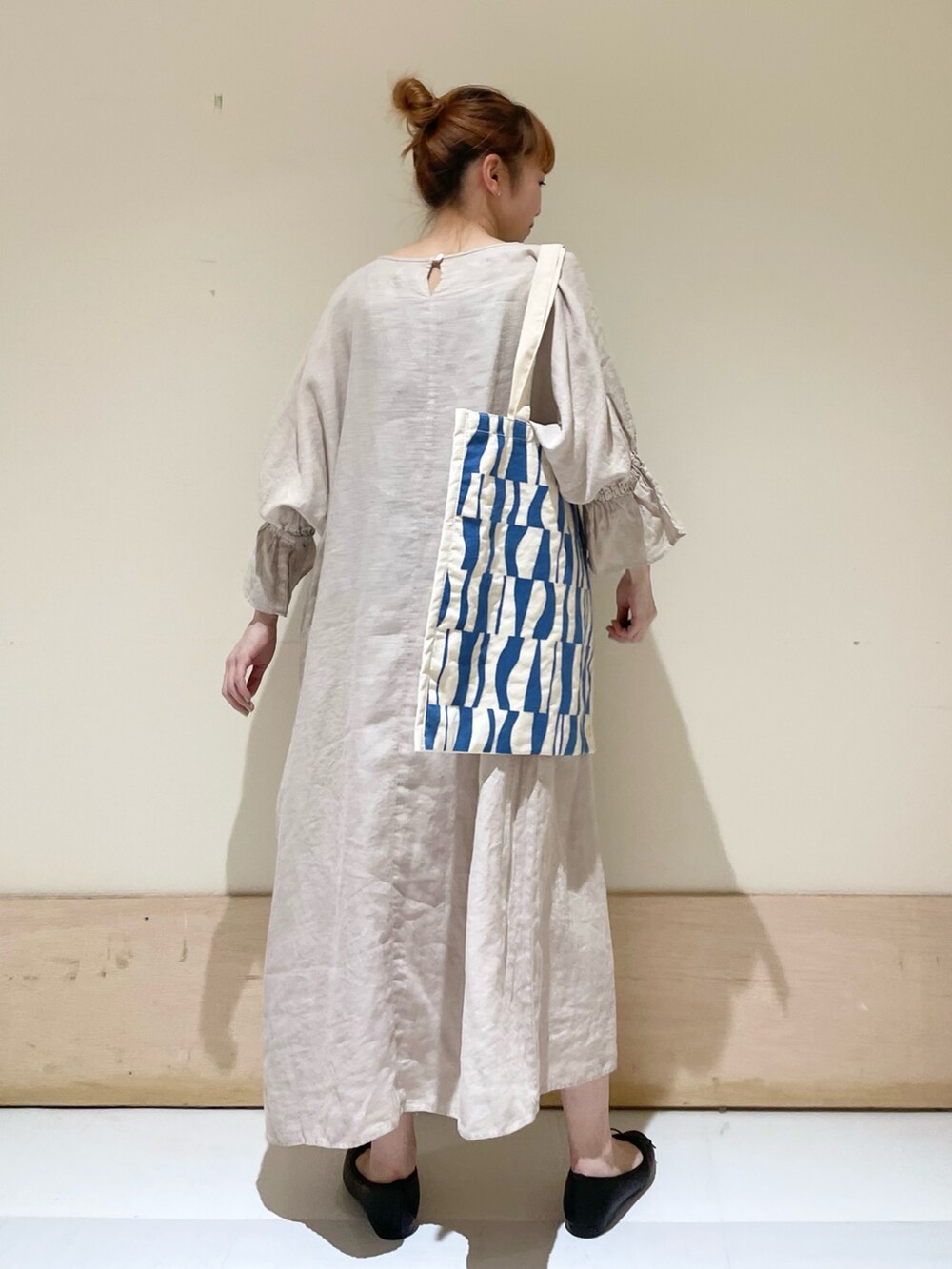 ベージュ系のワンピース、ブルー系のトートバッグ、ブラック系のバレエシューズを着用したレディースの春コーディネートの5枚目の写真