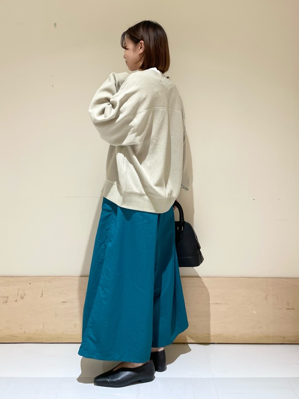 ベージュ系のカーディガン/ボレロ、ホワイト系のTシャツ/カットソー、ブラック系のショルダーバッグを着用したレディースの秋コーディネートの4枚目の写真