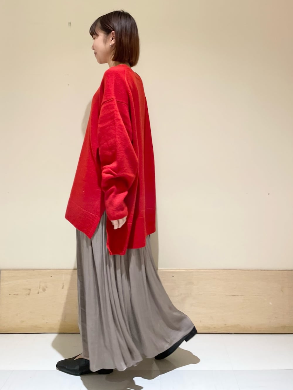 ブラック系のハンドバッグ、グレー系のスカート、ブラック系のパンプスを着用したレディースの秋コーディネートの4枚目の写真