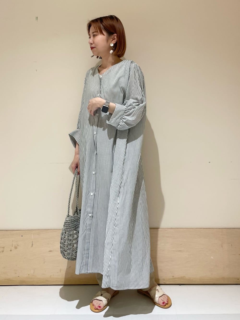 グリーン系のワンピース、グリーン系のかごバッグ、ベージュ系のその他パンツを着用したレディースの夏コーディネートの3枚目の写真