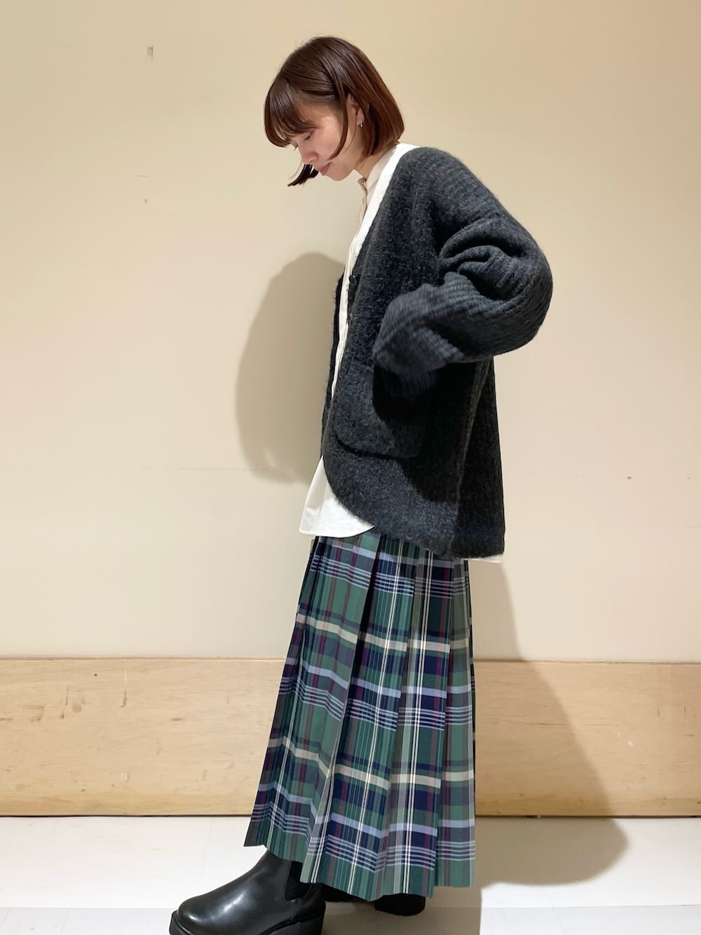 ホワイト系のシャツ/ブラウス、ブラック系のカーディガン/ボレロ、ブラック系のブーツを着用したレディースの秋コーディネートの4枚目の写真