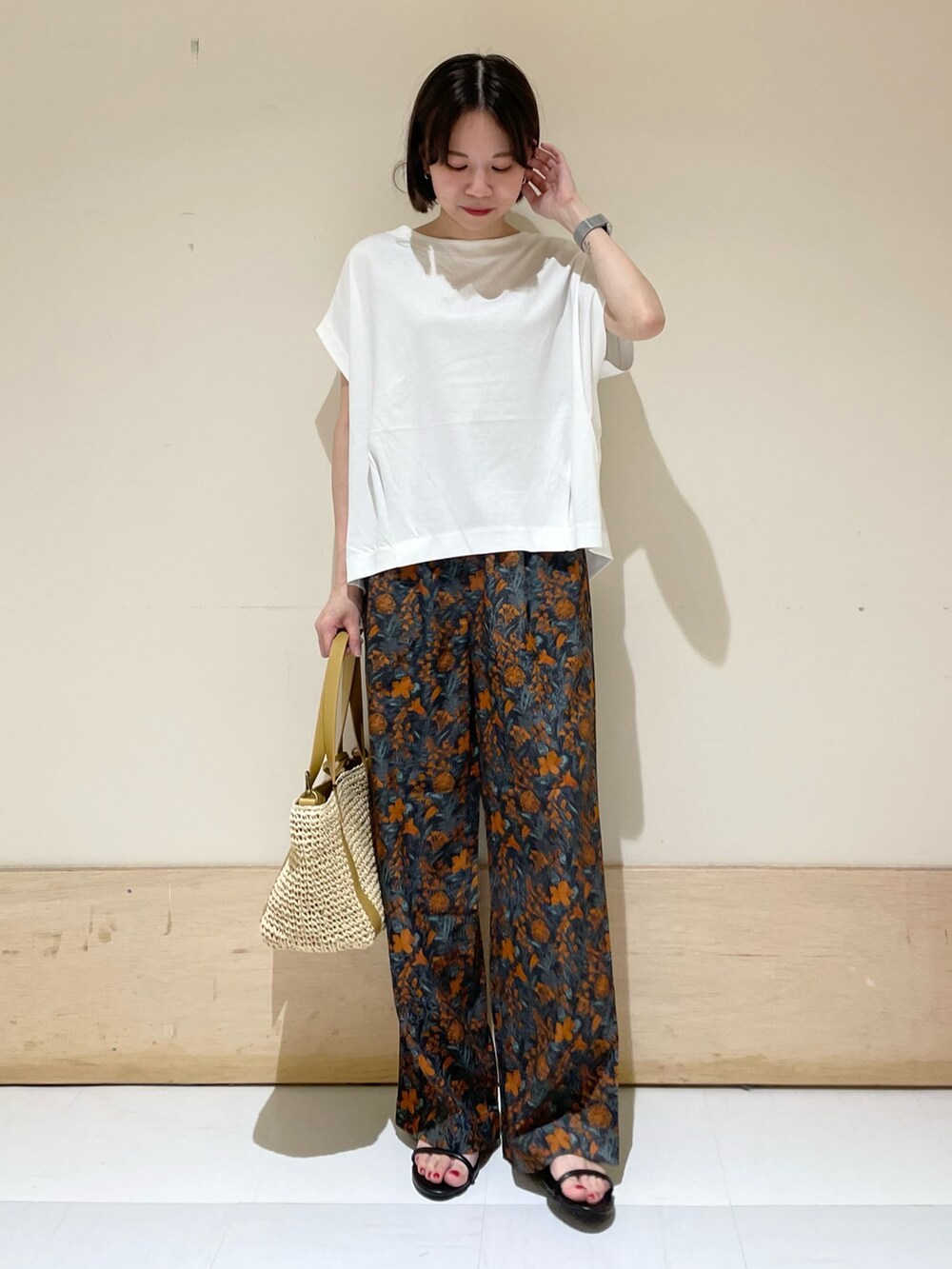 オレンジ系のその他パンツ、ホワイト系のTシャツ/カットソー、ベージュ系のトートバッグを着用したレディースの夏コーディネートの3枚目の写真