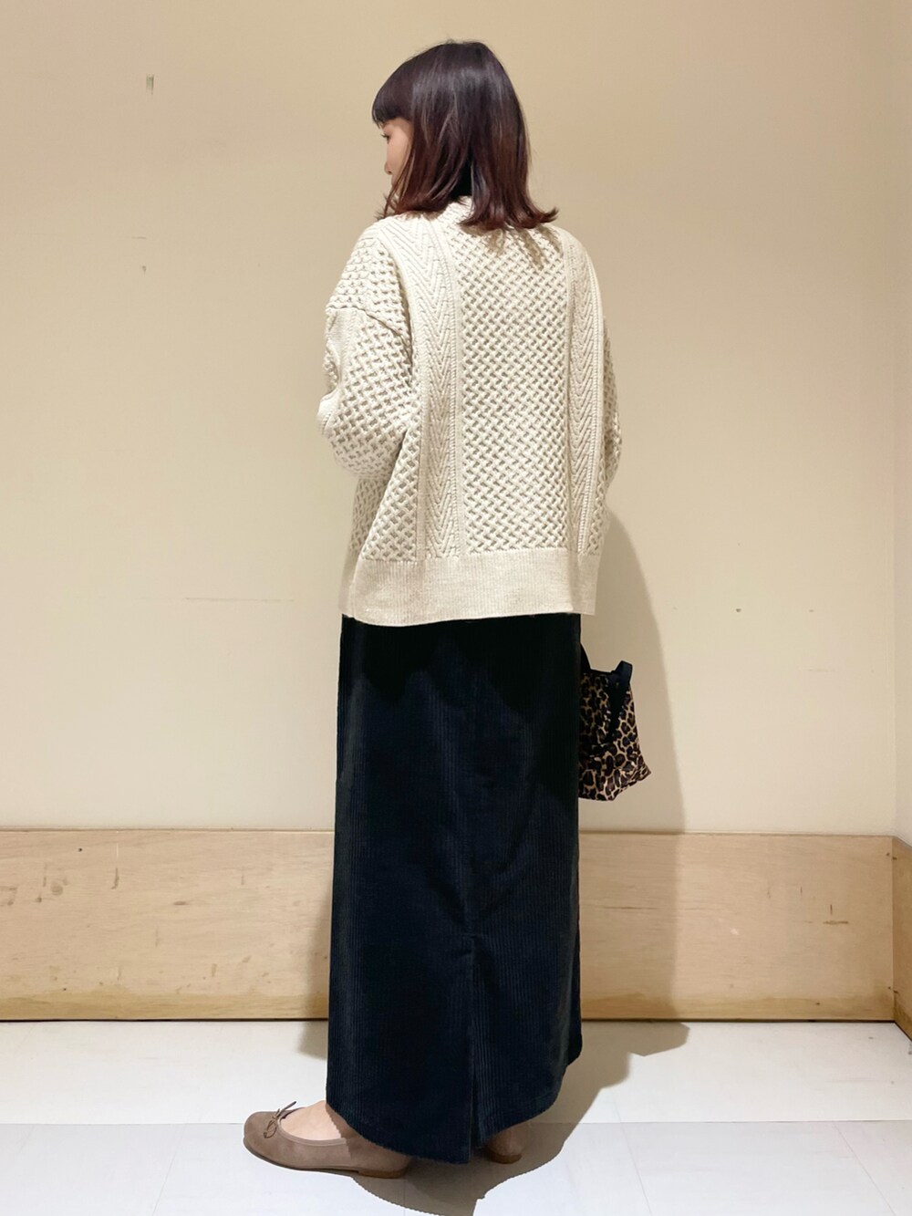 ホワイト系のカーディガン/ボレロ、ブラック系のスカート、ベージュ系のバレエシューズを着用したレディースの冬コーディネートの3枚目の写真