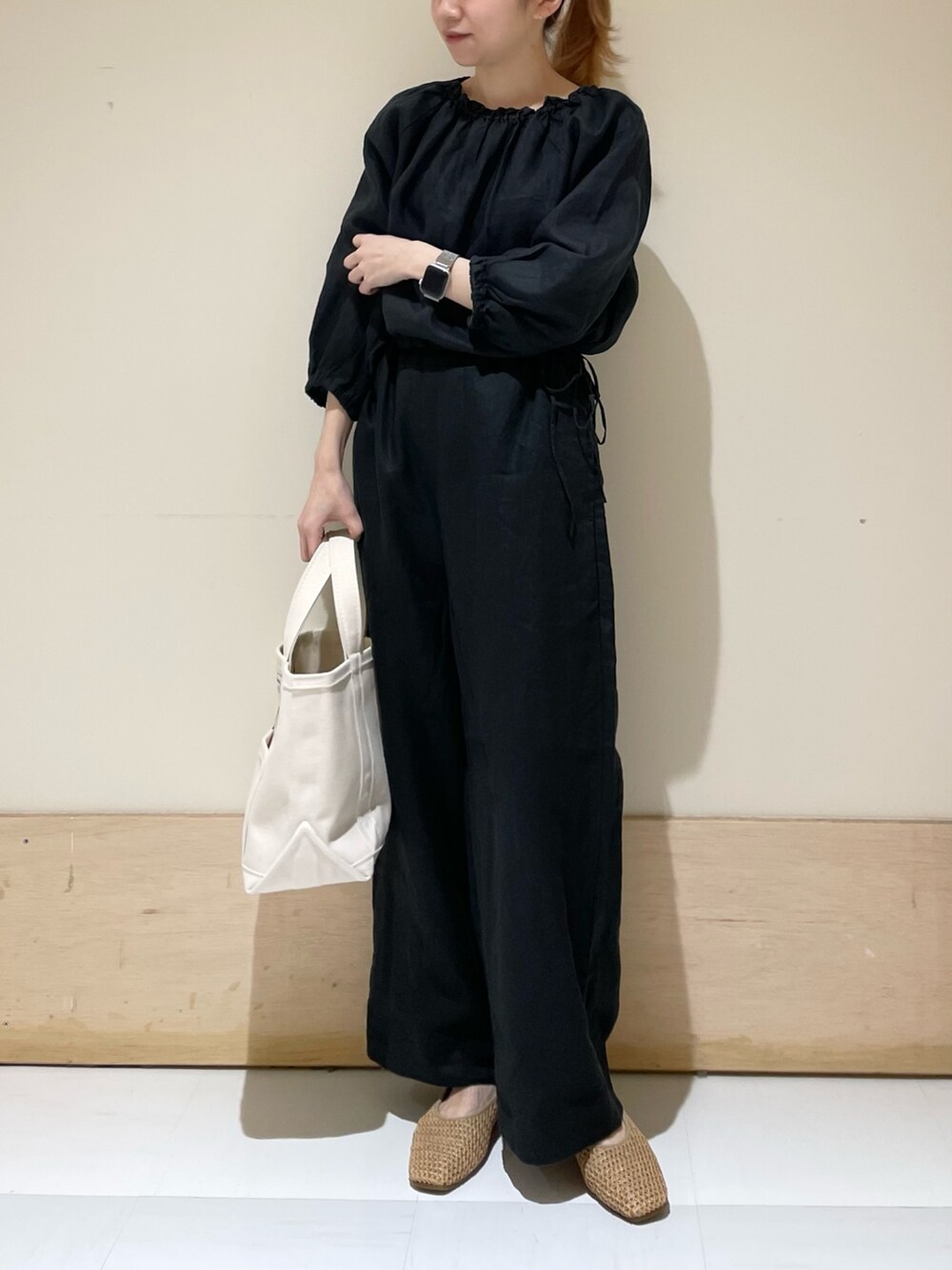 ブラック系のサロペット/オーバーオール、ベージュ系のバレエシューズ、ホワイト系のトートバッグを着用したレディースの春コーディネートの3枚目の写真