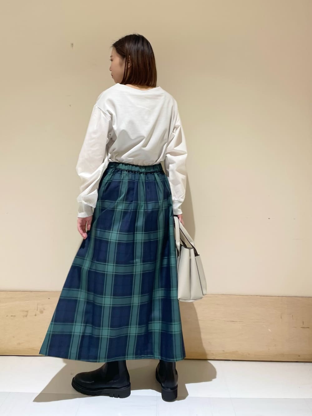 グレー系のTシャツ/カットソー、ブルー系のスカート、グレー系のトートバッグを着用したレディースの秋コーディネートの4枚目の写真