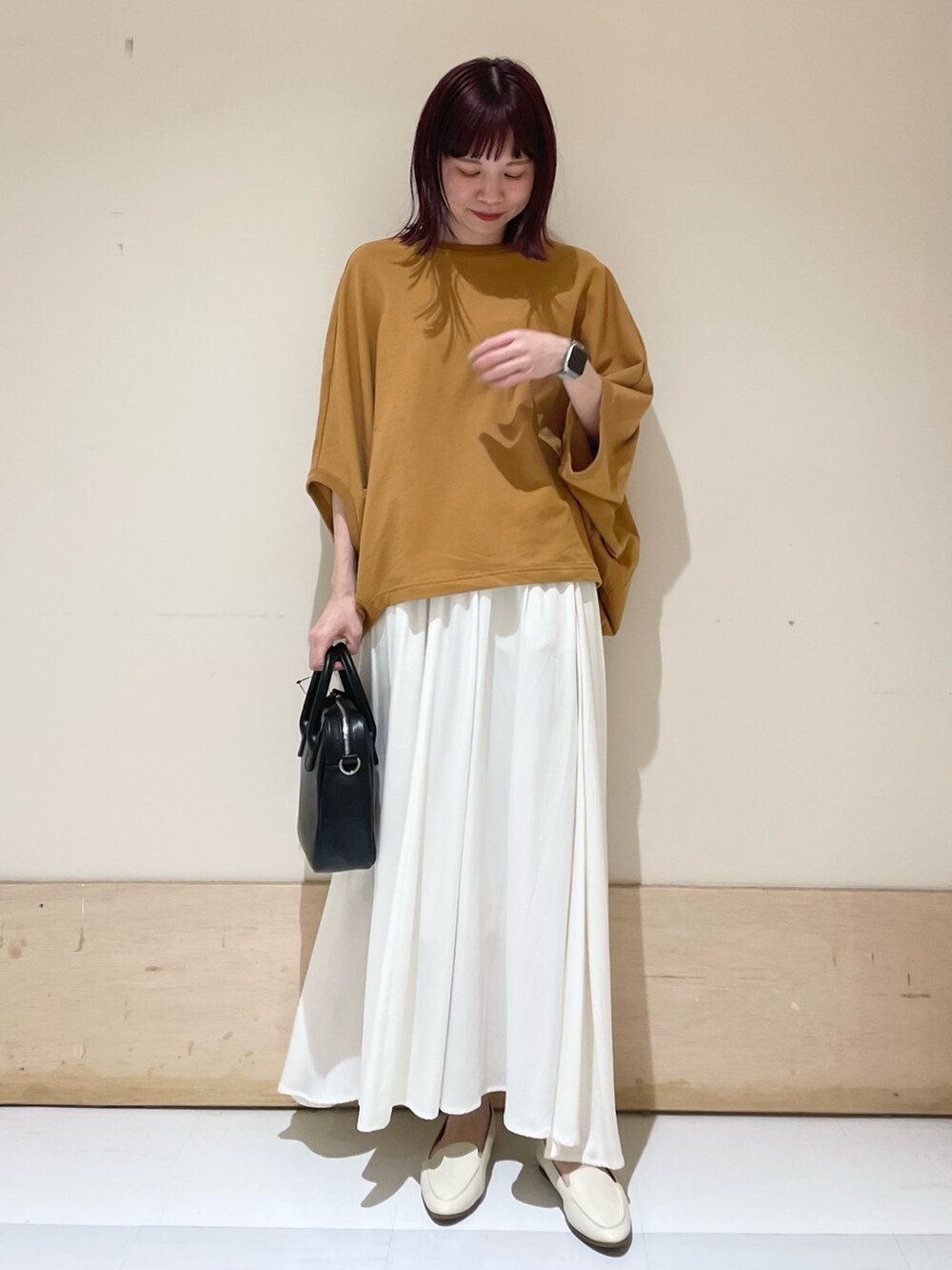 ホワイト系のスカート、イエロー系のTシャツ/カットソー、ブラック系のショルダーバッグを着用したレディースの春コーディネートの2枚目の写真