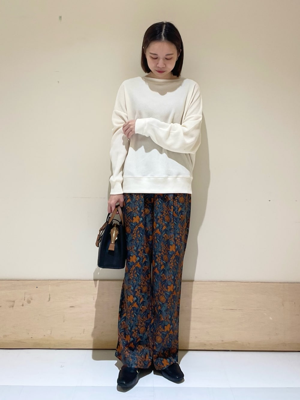 オレンジ系のその他パンツ、ブラック系のハンドバッグ、ブラック系のローファーを着用したレディースの秋コーディネートの3枚目の写真