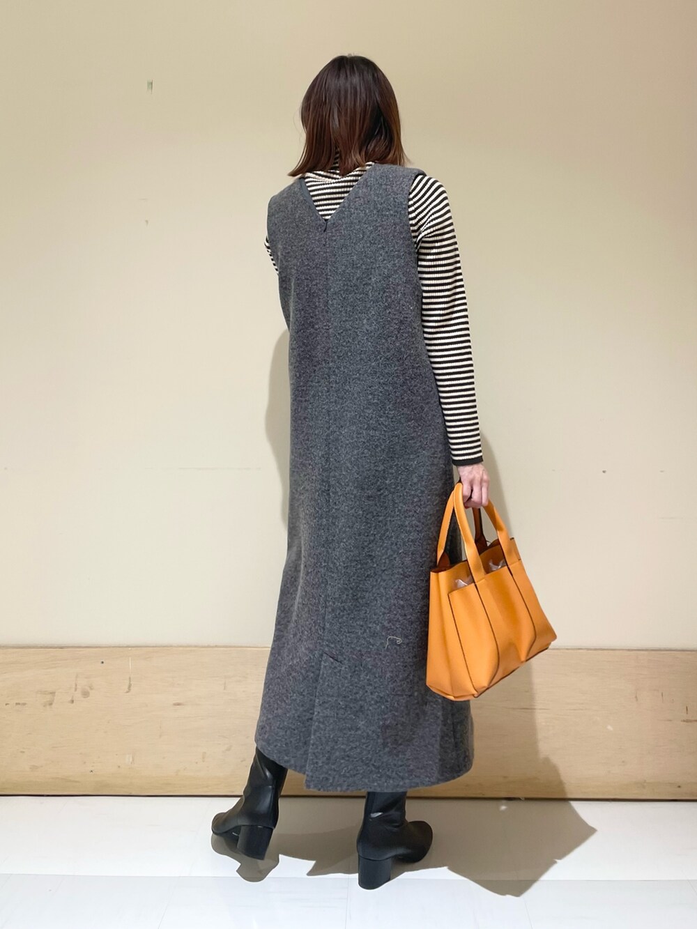 ホワイト系のニット/セーター、グレー系のワンピースを着用したレディースの冬コーディネートの7枚目の写真