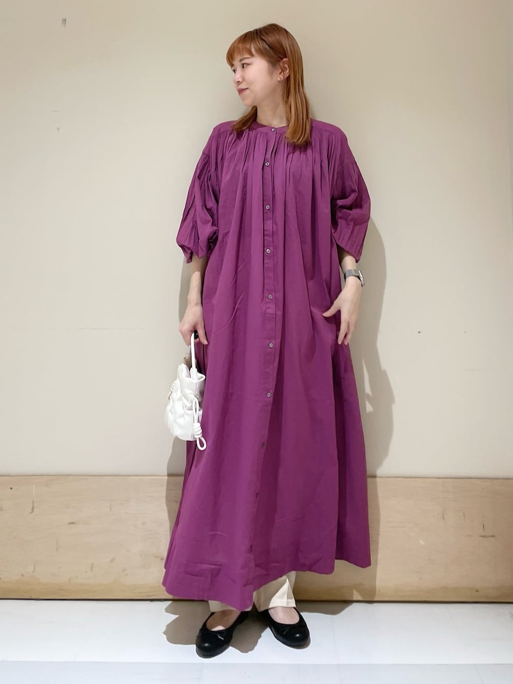ベージュ系のデニムパンツ、パープル系のワンピース、ホワイト系のショルダーバッグを着用したレディースの春コーディネートの2枚目の写真