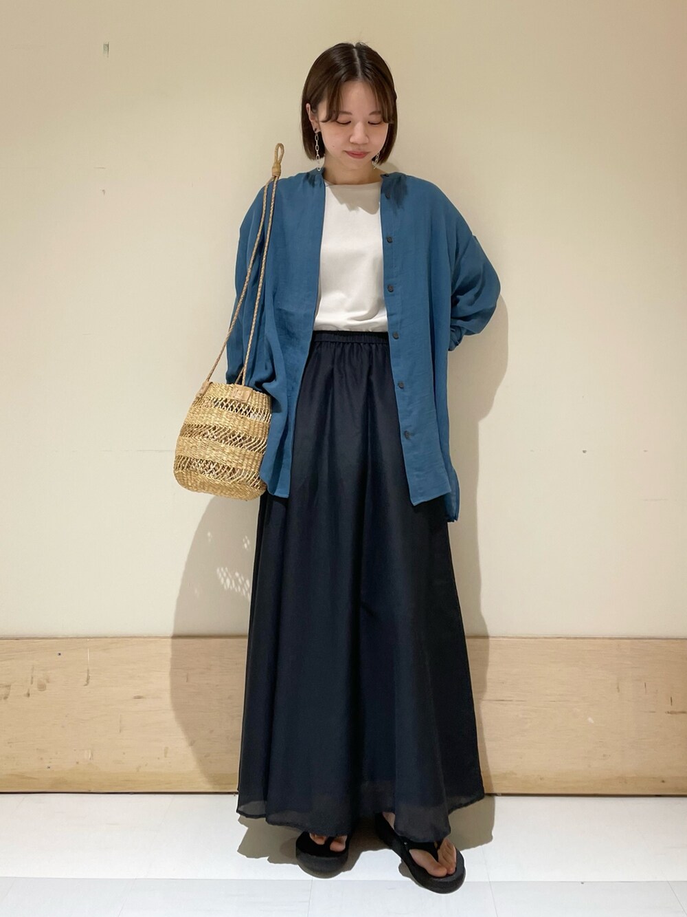 ブラック系のスカート、ベージュ系のショルダーバッグ、グレー系のTシャツ/カットソーを着用したレディースの夏コーディネートの3枚目の写真