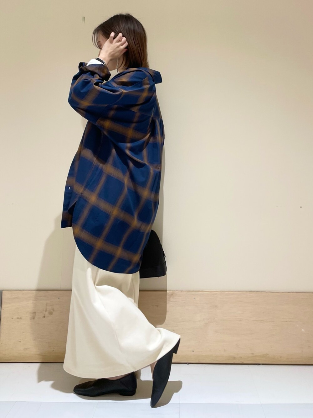 ベージュ系のスカート、ブラック系のパンプス、ブラック系のショルダーバッグを着用したレディースの秋コーディネートの5枚目の写真