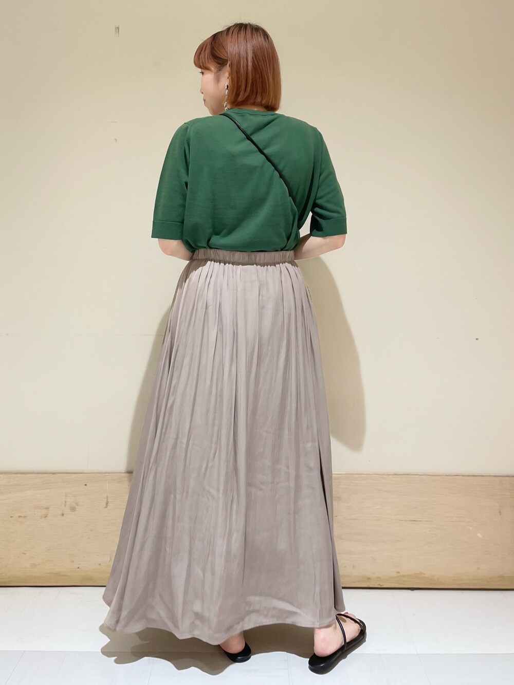 グレー系のスカート、ブラック系のサンダル、ブラック系のショルダーバッグを着用したレディースの春コーディネートの6枚目の写真