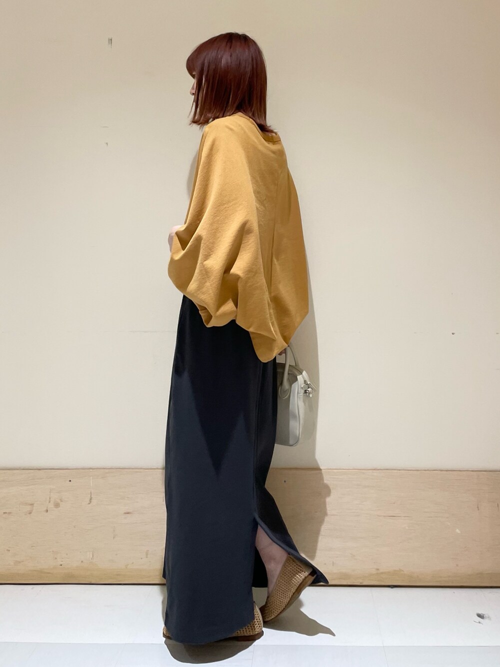 イエロー系のTシャツ/カットソー、ベージュ系のパンプス、グレー系のスカートを着用したレディースの春コーディネートの6枚目の写真