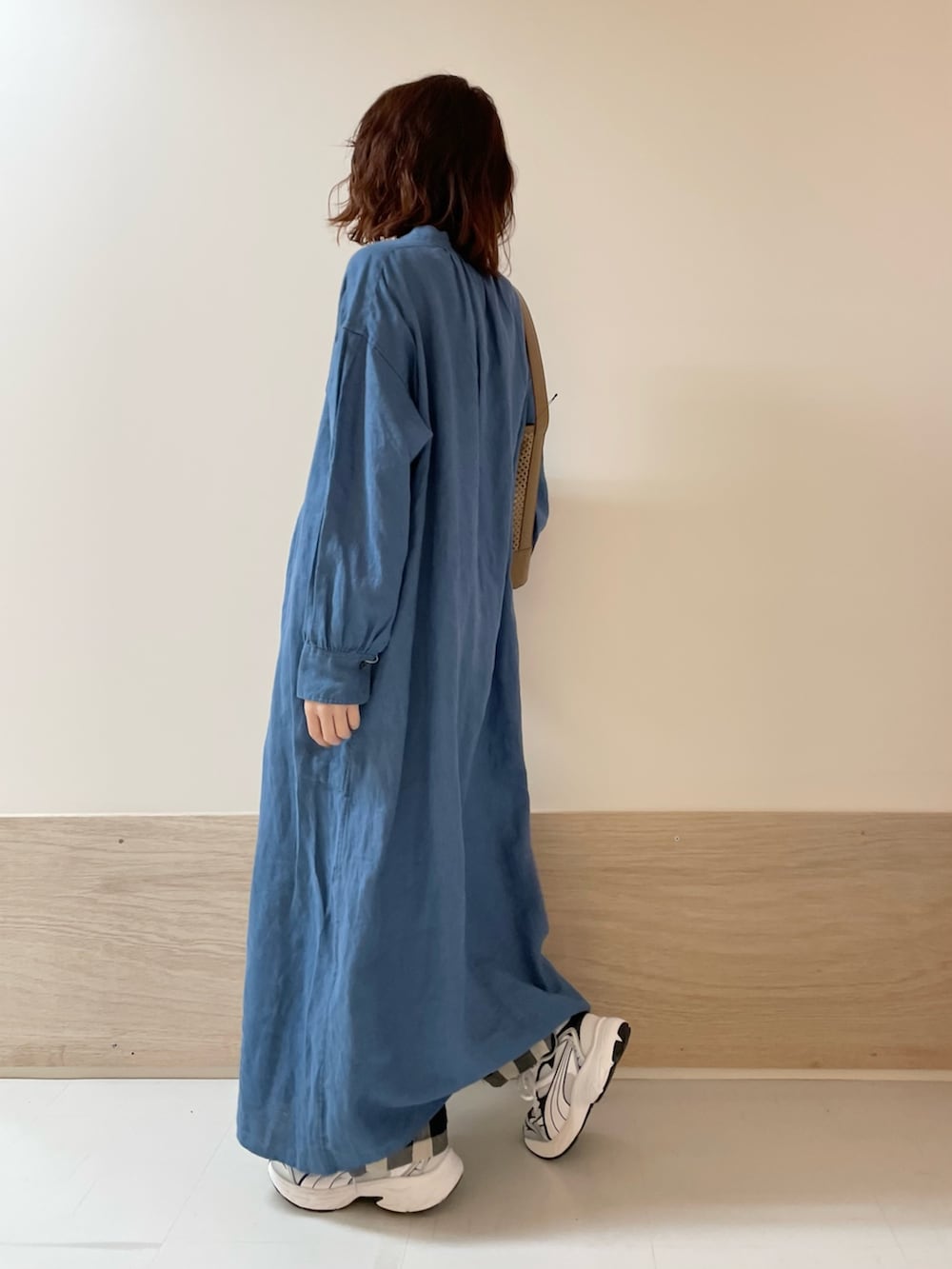 ブラック系のその他パンツ、ブルー系のワンピース、ベージュ系のショルダーバッグを着用したレディースの春コーディネートの5枚目の写真