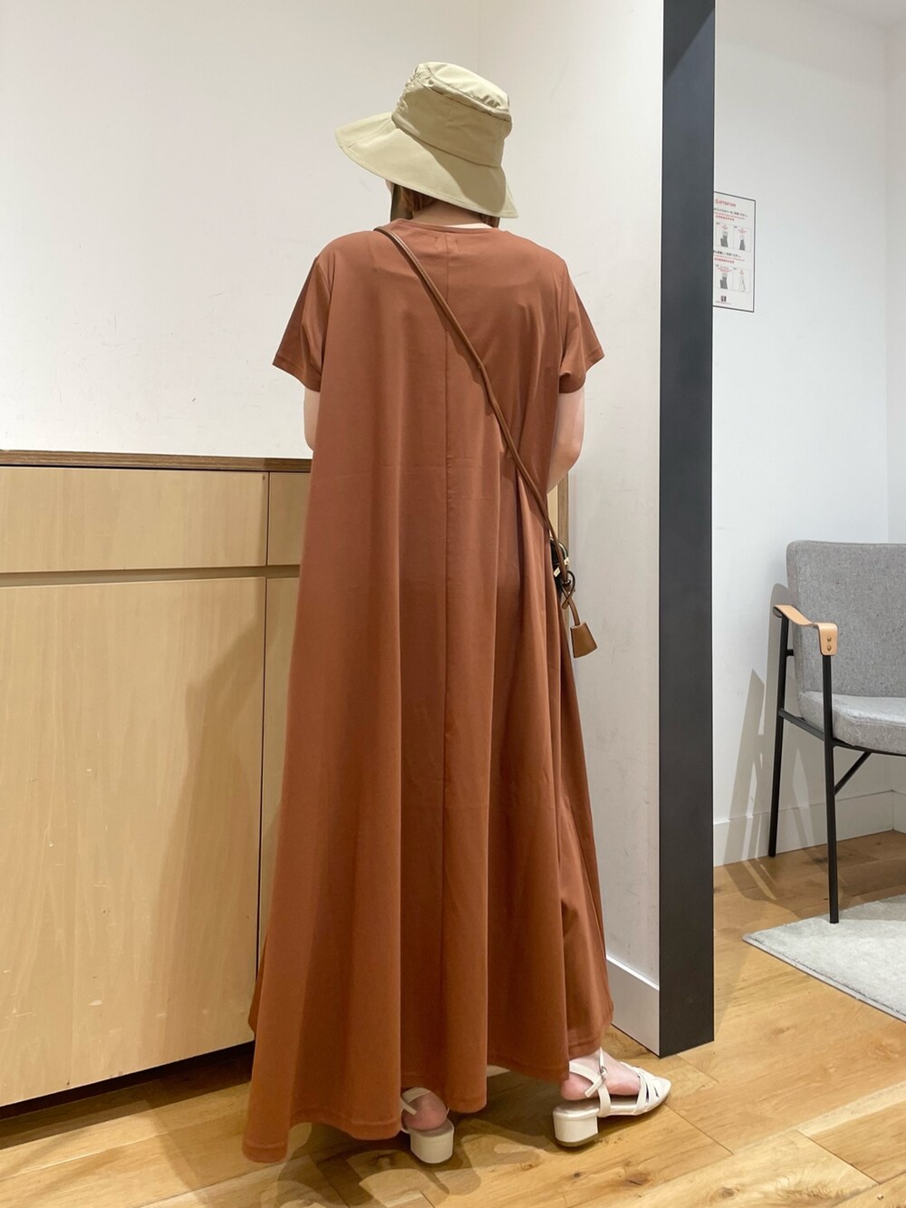 ホワイト系のサンダル、ブラウン系のワンピース、ブラック系のショルダーバッグを着用したレディースの夏コーディネートの7枚目の写真