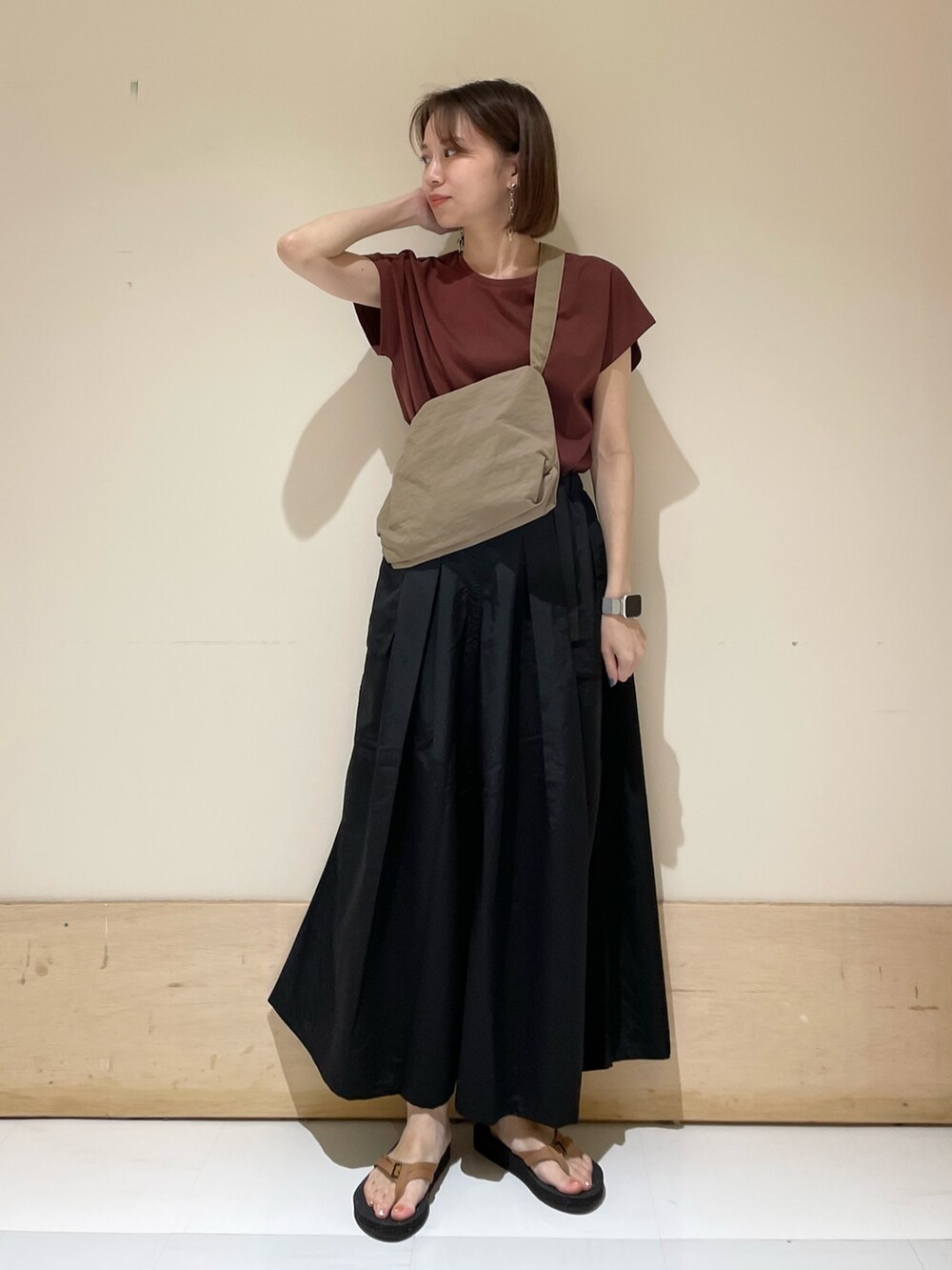 レッド系のTシャツ/カットソー、オレンジ系のサンダル、ベージュ系のショルダーバッグを着用したレディースの夏コーディネートの2枚目の写真