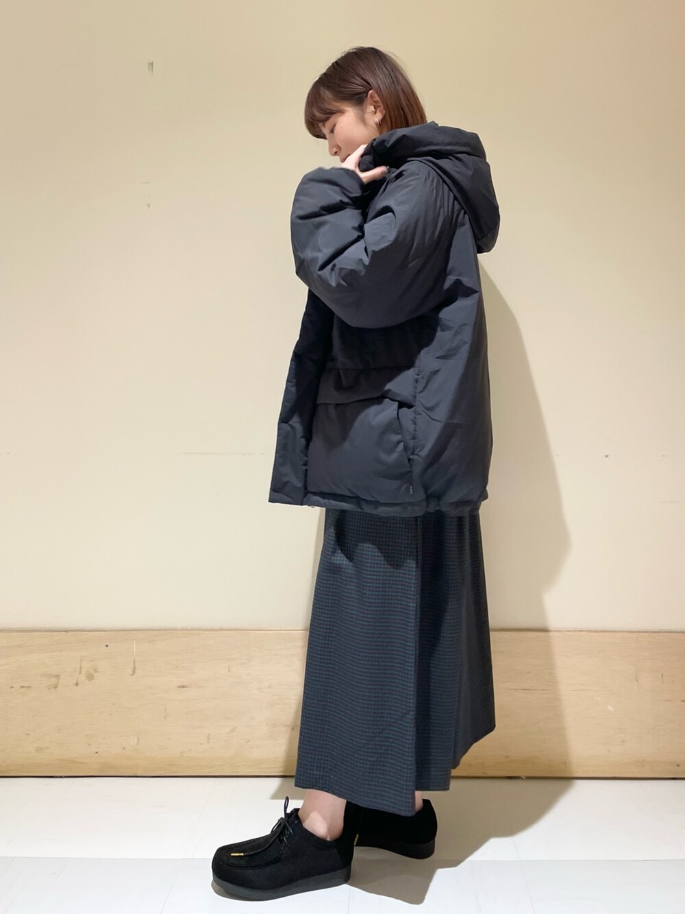 ブルー系のワンピース、ブラック系のダウンジャケット/コート、ホワイト系のTシャツ/カットソーを着用したレディースの冬コーディネートの5枚目の写真