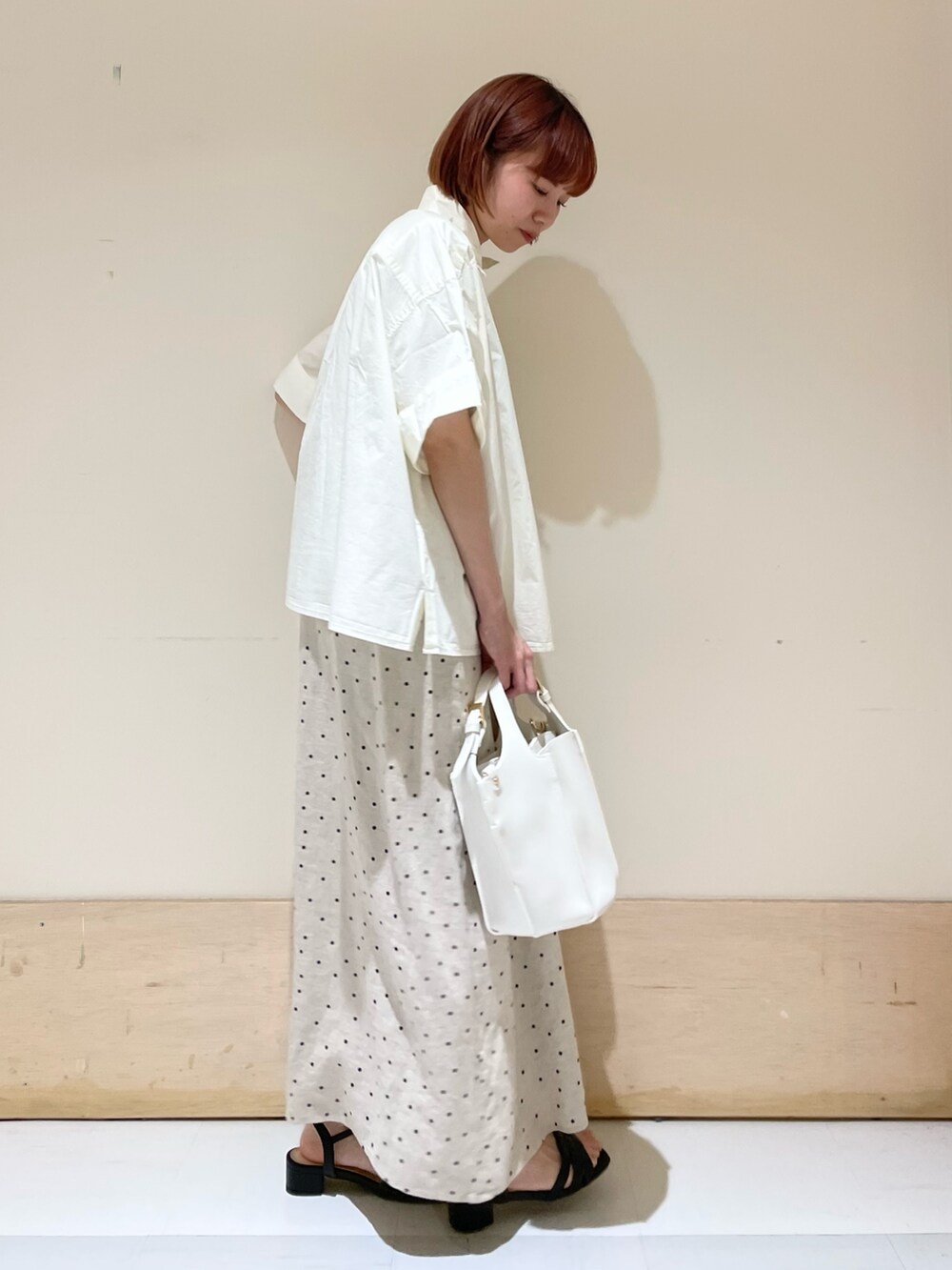 ベージュ系のワンピース、ホワイト系のトートバッグ、ホワイト系のシャツ/ブラウスを着用したレディースの春コーディネートの6枚目の写真