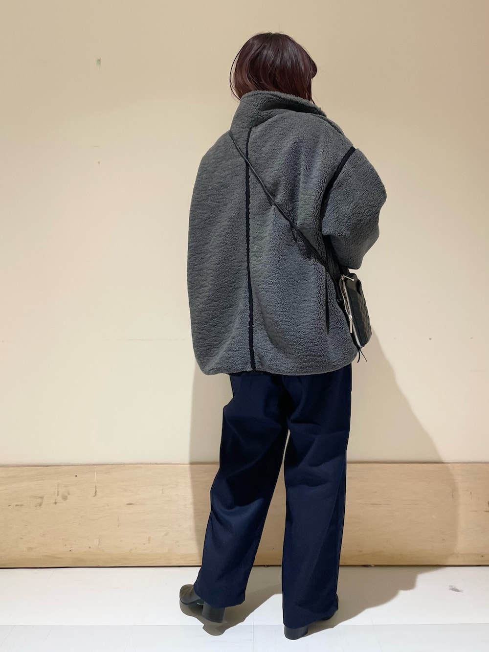 グリーン系のニット/セーター、グレー系のブルゾン、ブルー系のその他パンツを着用したレディースの冬コーディネートの6枚目の写真