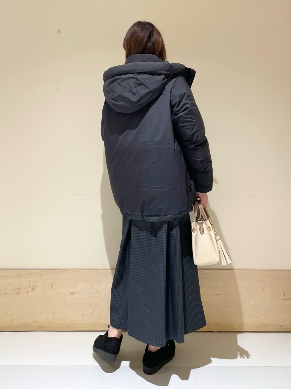 ブルー系のワンピース、ブラック系のダウンジャケット/コート、ホワイト系のTシャツ/カットソーを着用したレディースの冬コーディネートの6枚目の写真