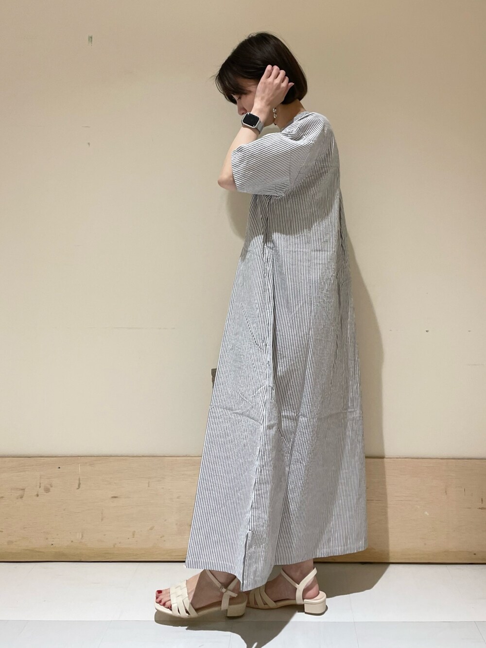 ベージュ系のトートバッグ、ホワイト系のサンダル、ブラック系のワンピースを着用したレディースの夏コーディネートの4枚目の写真