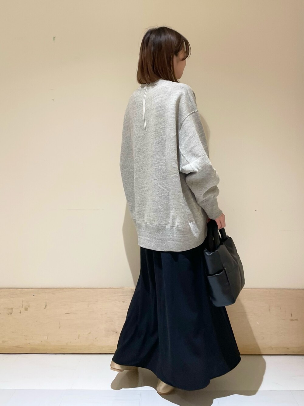 ブラック系のトートバッグ、ゴールド系のパンプス、グレー系のスウェットを着用したレディースの秋コーディネートの7枚目の写真