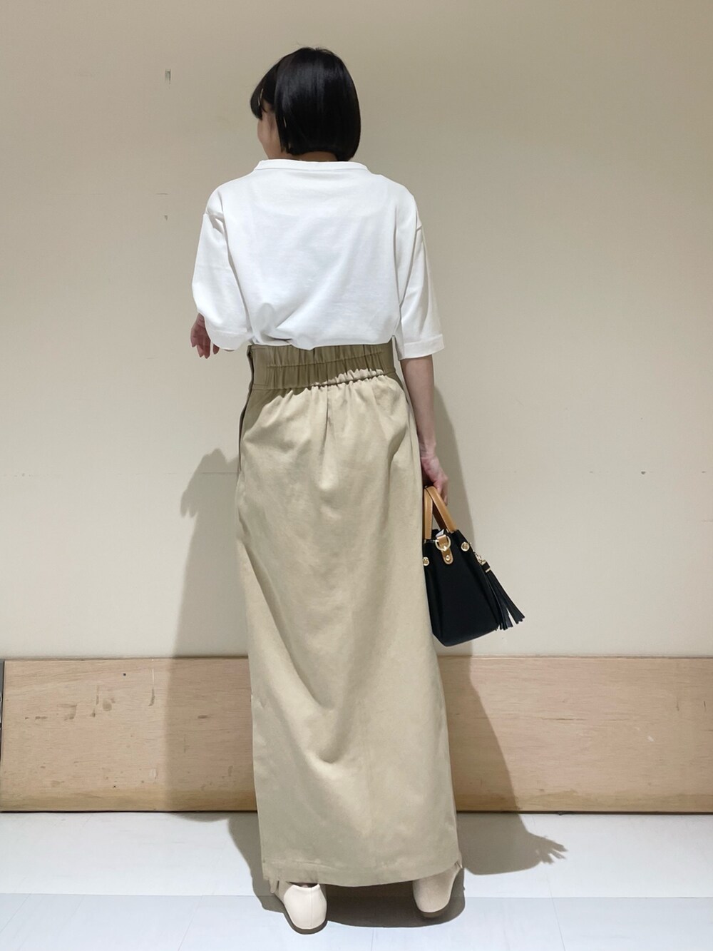 ホワイト系のTシャツ/カットソー、ブラック系のトートバッグ、ベージュ系のスカートを着用したレディースの夏コーディネートの5枚目の写真