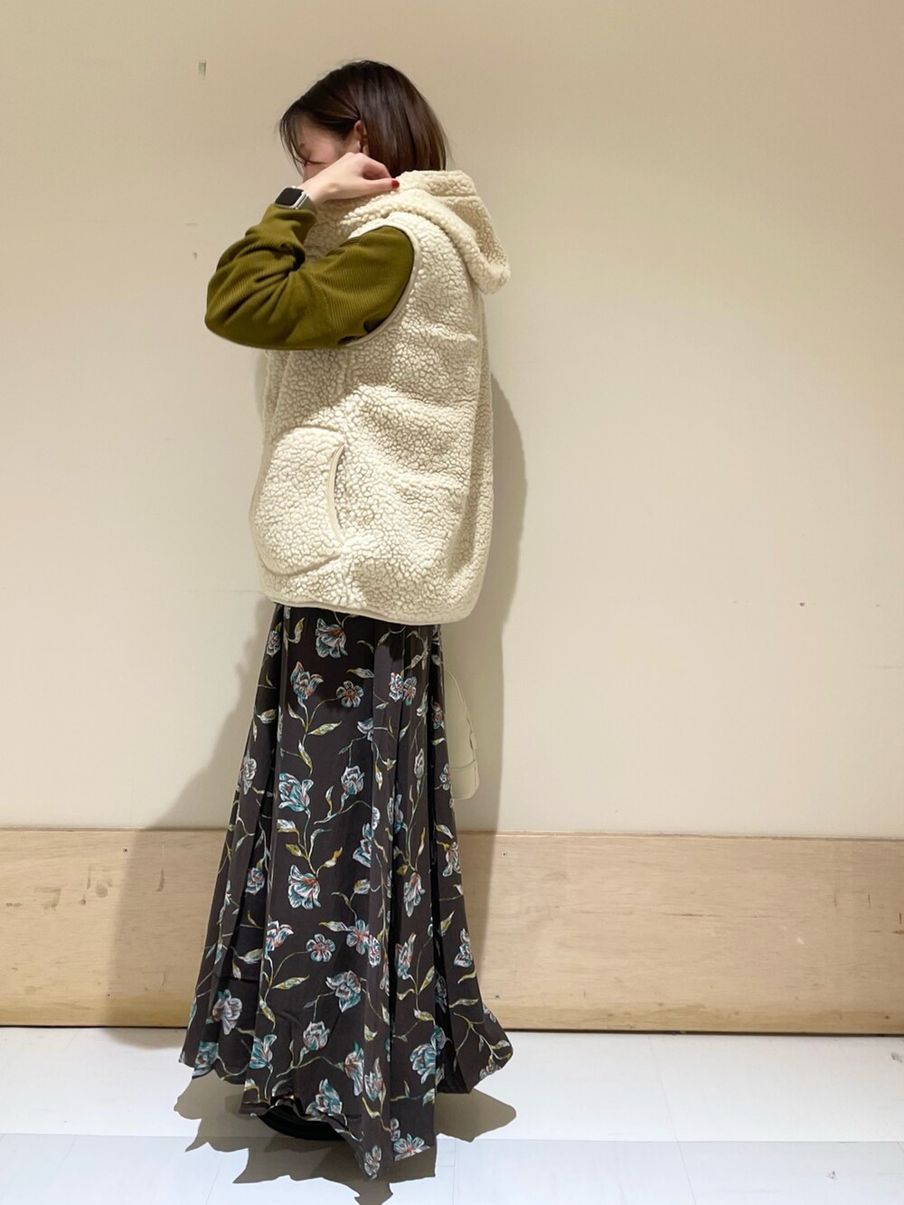 ホワイト系のショルダーバッグ、ブラック系のレインシューズ、イエロー系のTシャツ/カットソーを着用したレディースの秋コーディネートの4枚目の写真