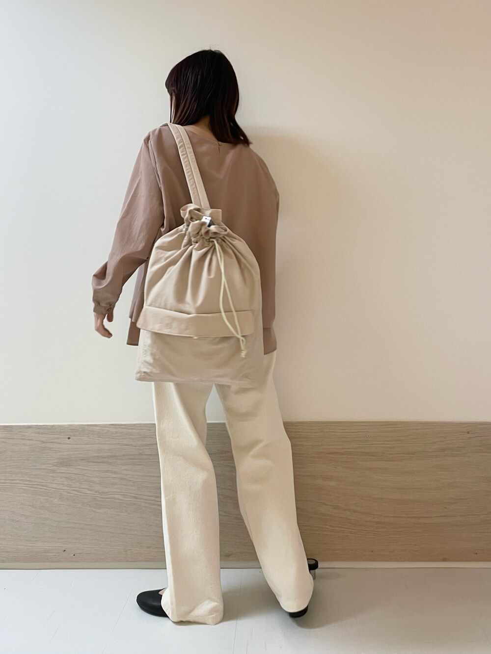 ベージュ系のデニムパンツ、ブラック系のパンプス、ピンク系のバックパック/リュックを着用したレディースの春コーディネートの5枚目の写真