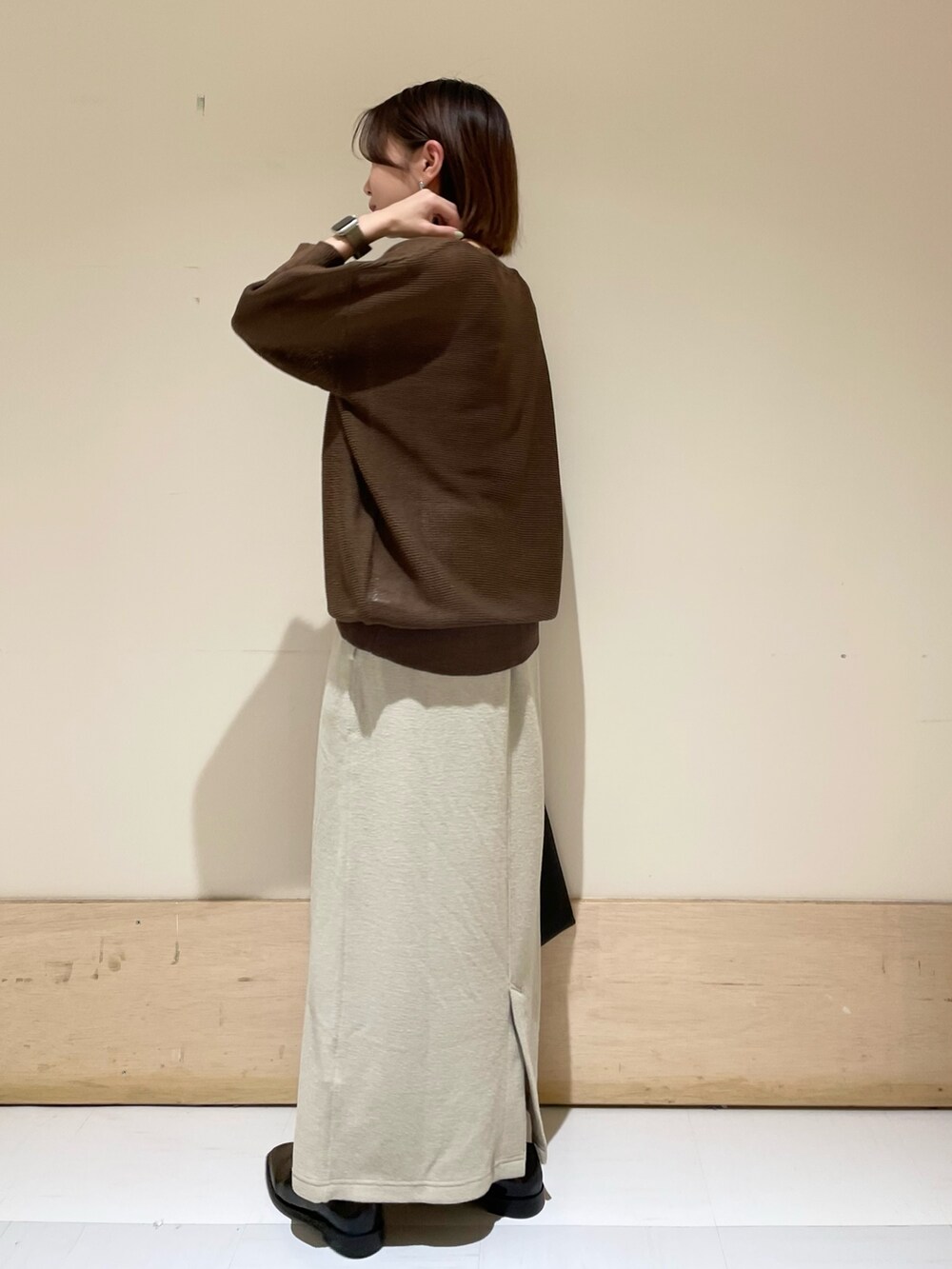 ブラウン系のニット/セーター、ベージュ系のスカート、ブラック系のドレスシューズを着用したレディースの秋コーディネートの6枚目の写真