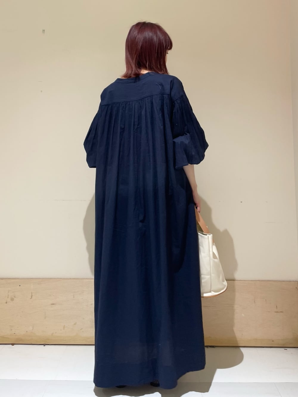 ホワイト系のトートバッグ、ブルー系のワンピース、ブラウン系のパンプスを着用したレディースの春コーディネートの8枚目の写真