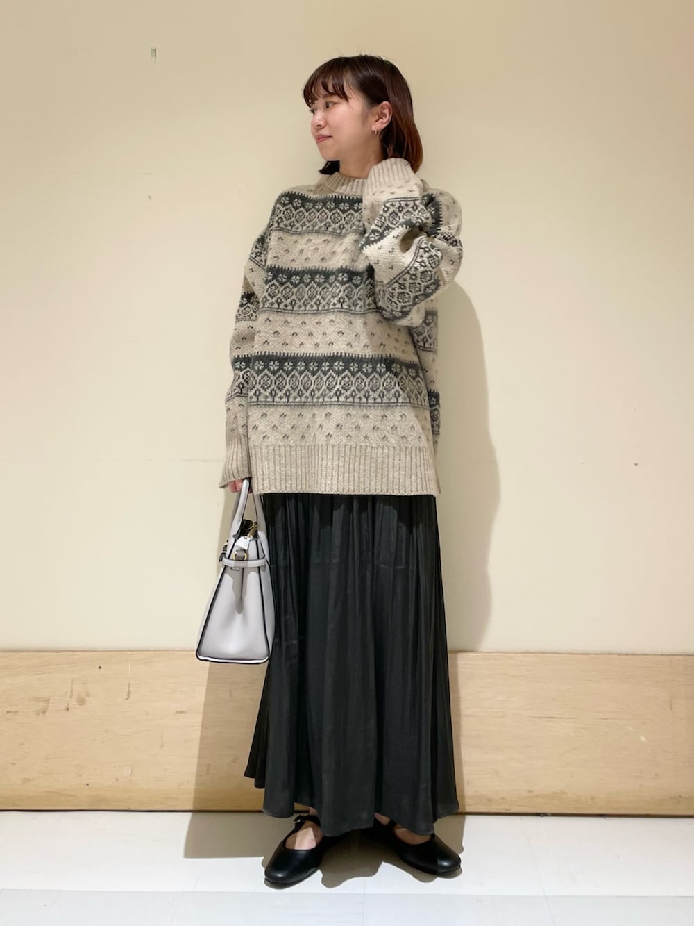 ベージュ系のニット/セーター、グレー系のスカート、ブラック系のその他シューズを着用したレディースの冬コーディネートの3枚目の写真