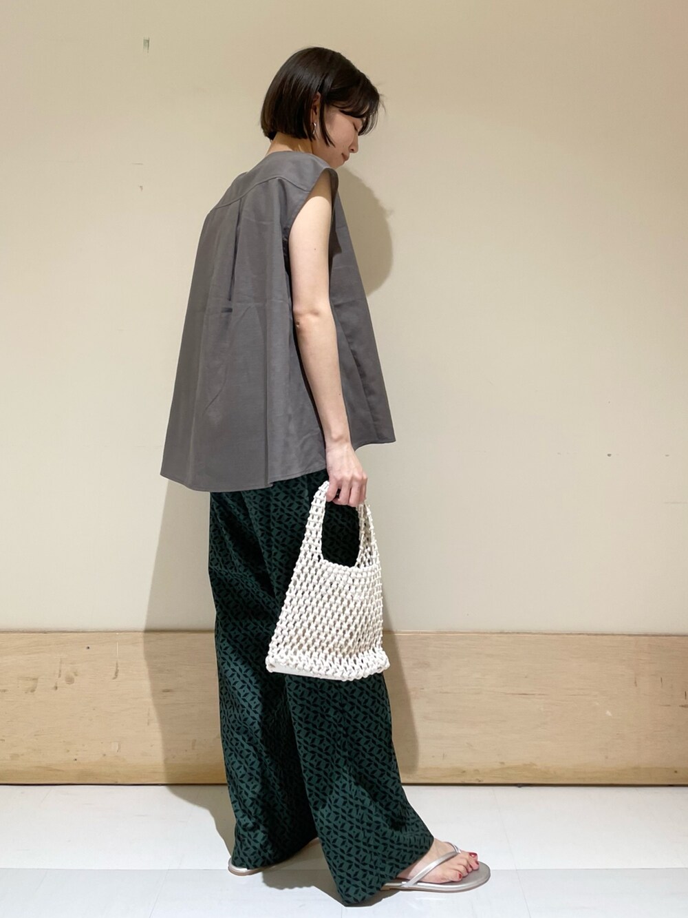 グレー系のシャツ/ブラウス、ホワイト系のハンドバッグ、シルバー系のサンダルを着用したレディースの夏コーディネートの5枚目の写真