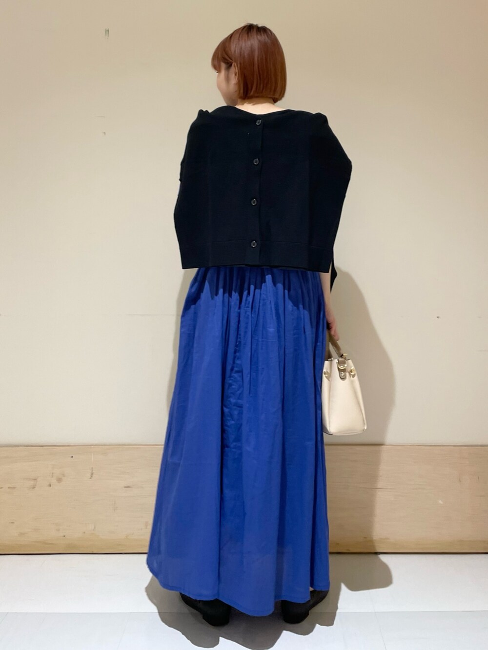 ブルー系のワンピース、ブラック系のカーディガン/ボレロ、ホワイト系のトートバッグを着用したレディースの春コーディネートの9枚目の写真