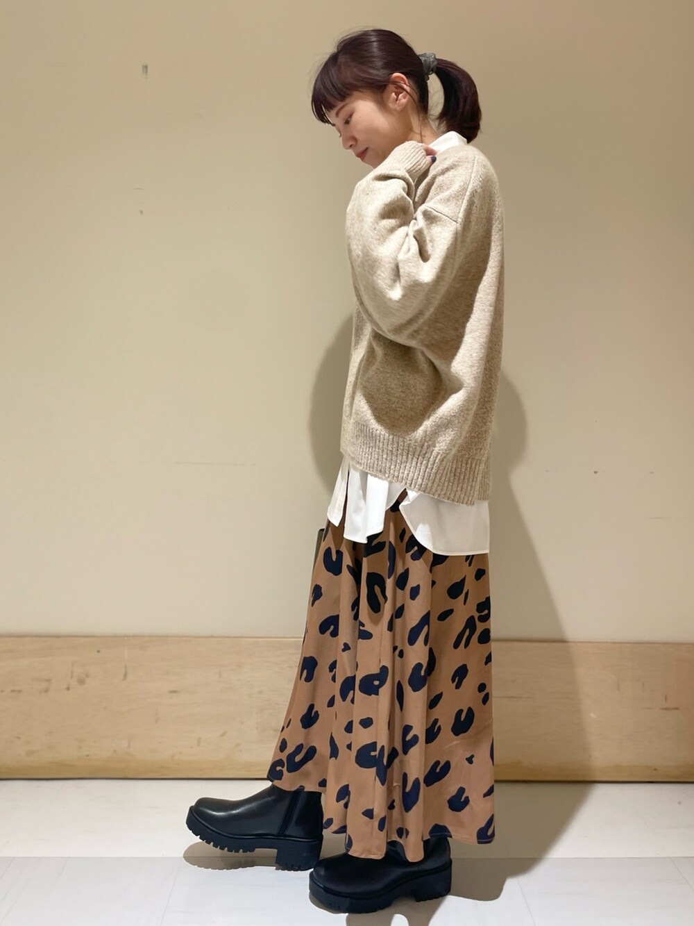 ベージュ系のニット/セーター、ホワイト系のシャツ/ブラウス、イエロー系のスカートを着用したレディースの冬コーディネートの3枚目の写真