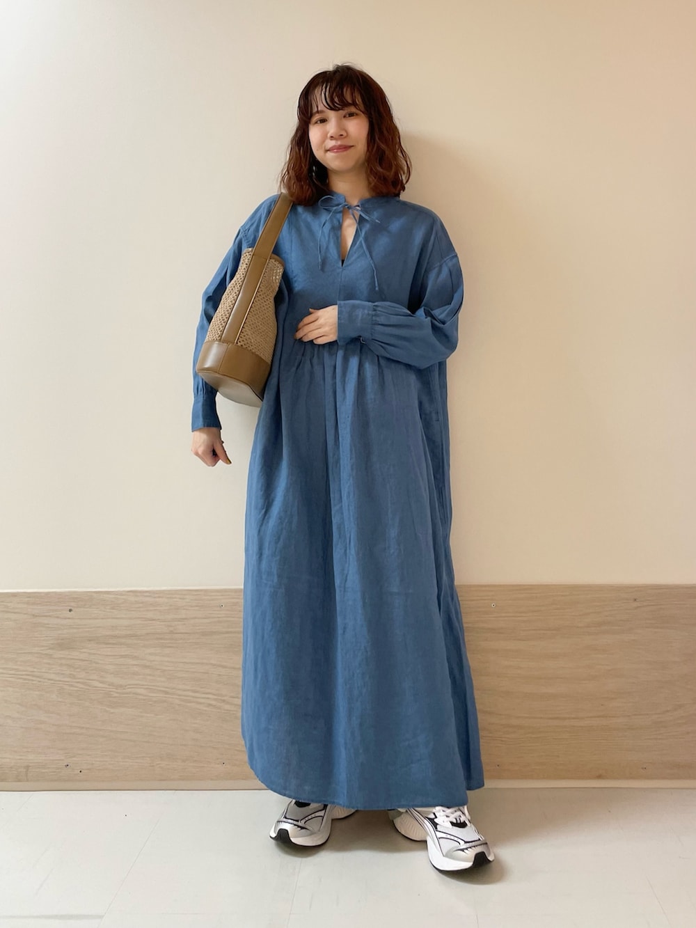 ブラック系のその他パンツ、ブルー系のワンピース、ベージュ系のショルダーバッグを着用したレディースの春コーディネートの2枚目の写真