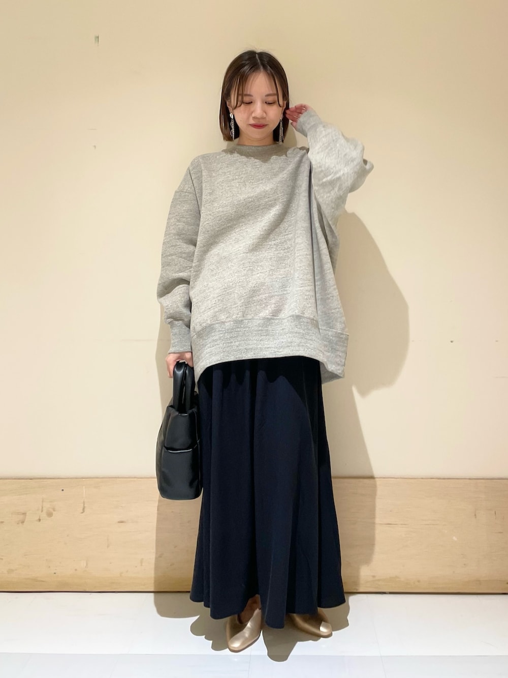 ブラック系のトートバッグ、ゴールド系のパンプス、グレー系のスウェットを着用したレディースの秋コーディネートの3枚目の写真