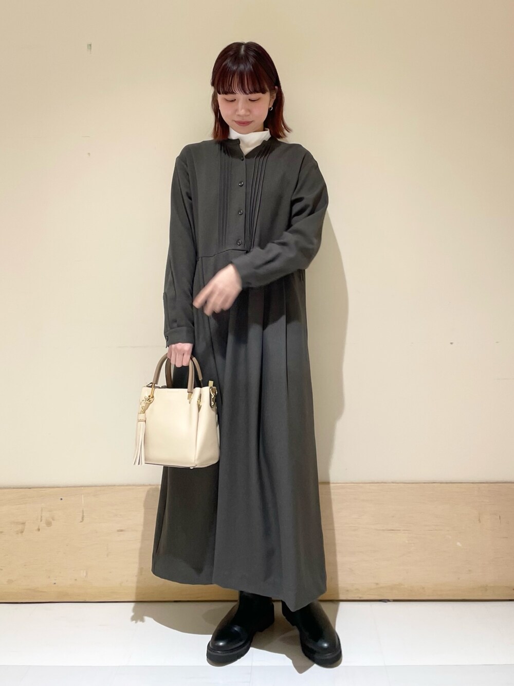 ブラック系のブーツ、グレー系のワンピース、ホワイト系のTシャツ/カットソーを着用したレディースの冬コーディネートの3枚目の写真