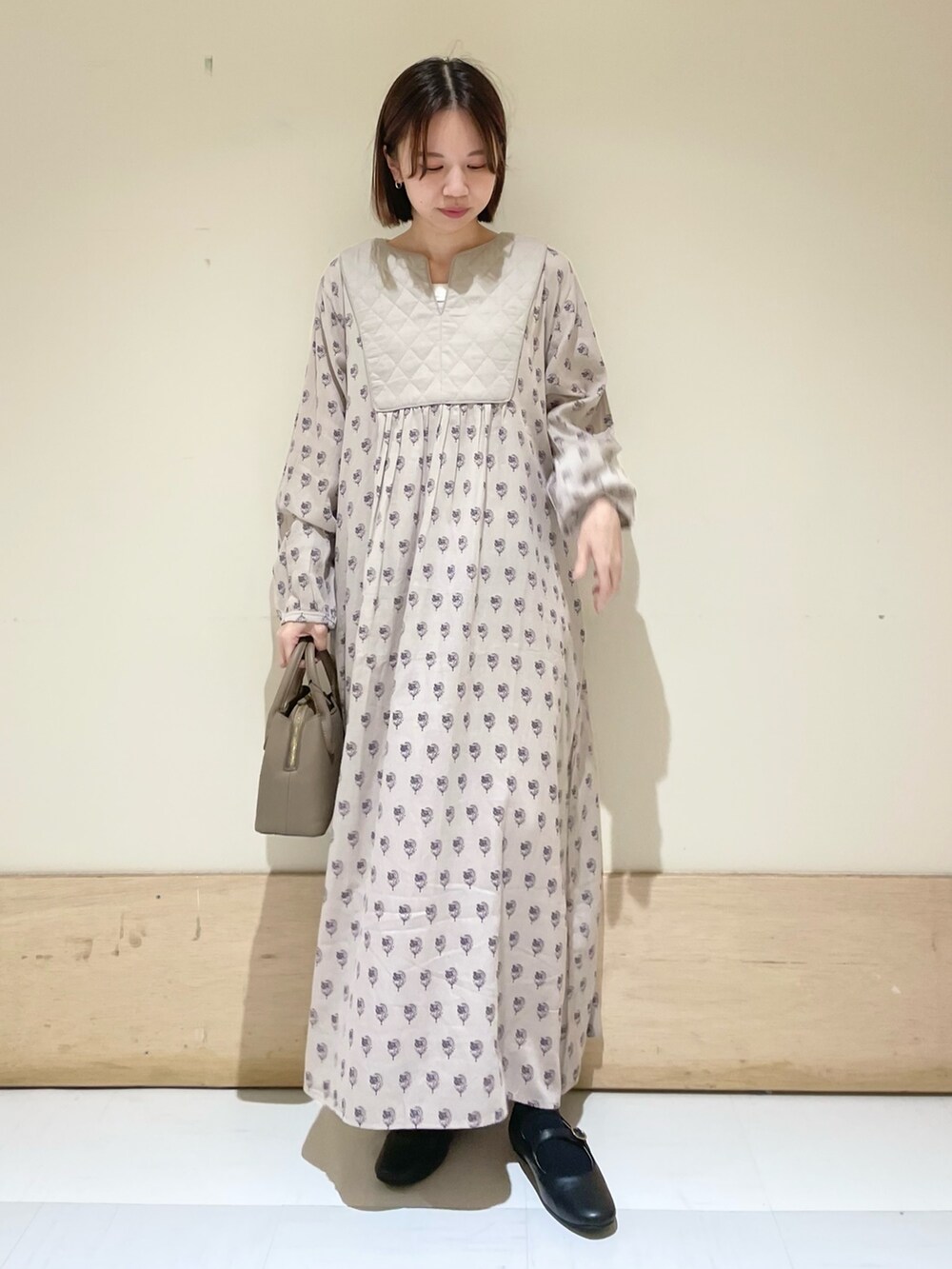 ブラック系のその他シューズ、ベージュ系のワンピース、グレー系のショルダーバッグを着用したレディースの秋コーディネートの2枚目の写真