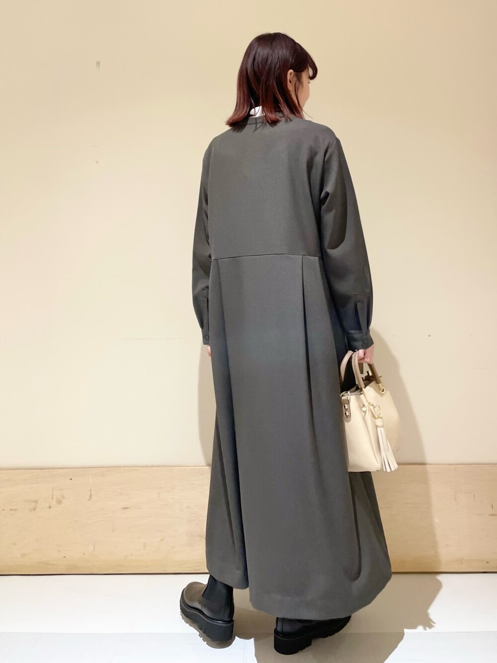 ブラック系のブーツ、グレー系のワンピース、ホワイト系のTシャツ/カットソーを着用したレディースの冬コーディネートの6枚目の写真