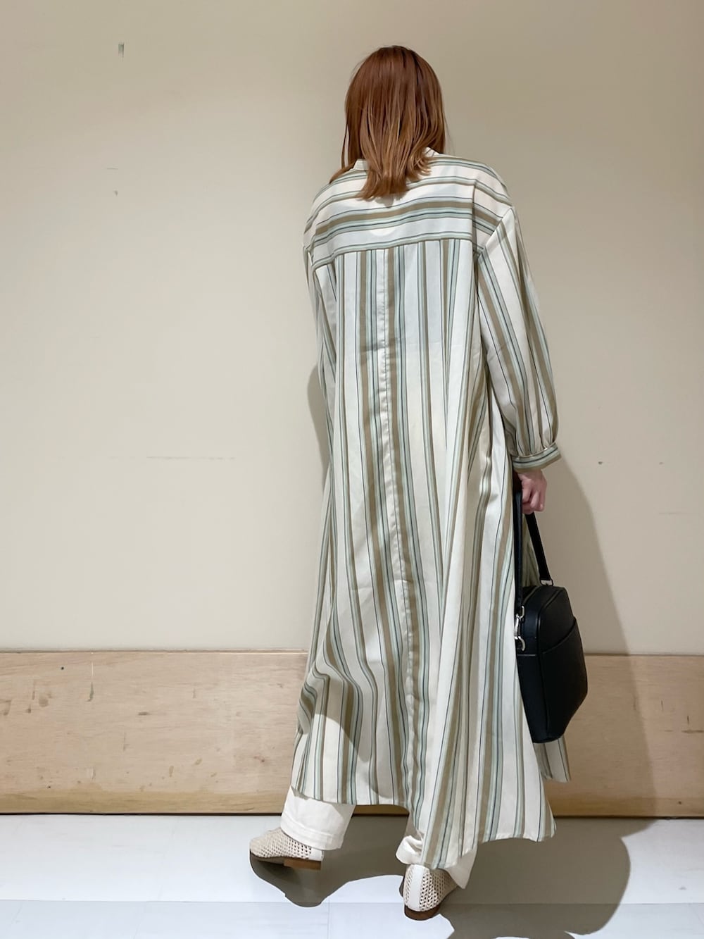 グリーン系のワンピース、ホワイト系のパンプス、ブラック系のショルダーバッグを着用したレディースの春コーディネートの6枚目の写真