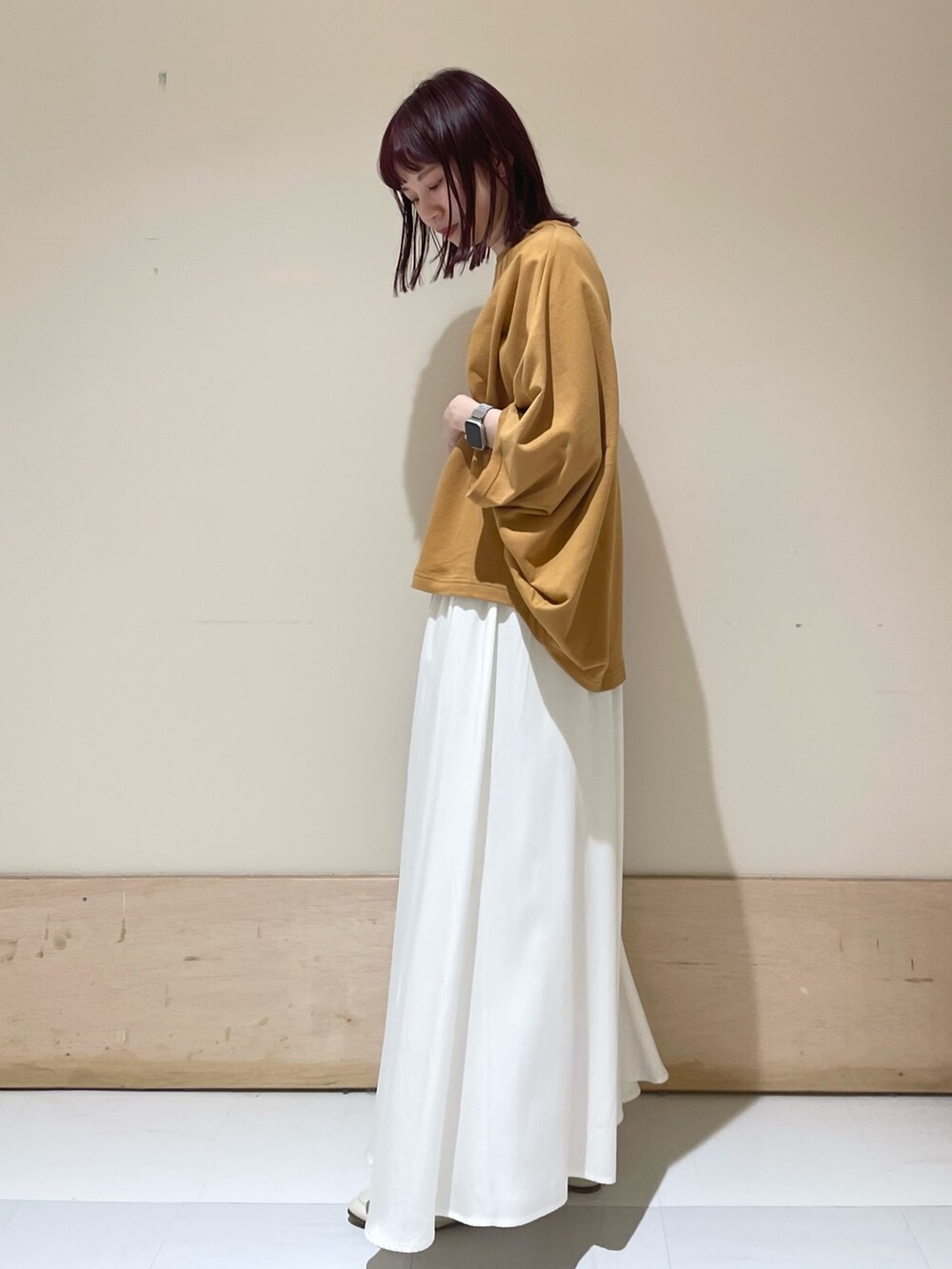 ホワイト系のスカート、イエロー系のTシャツ/カットソー、ブラック系のショルダーバッグを着用したレディースの春コーディネートの4枚目の写真