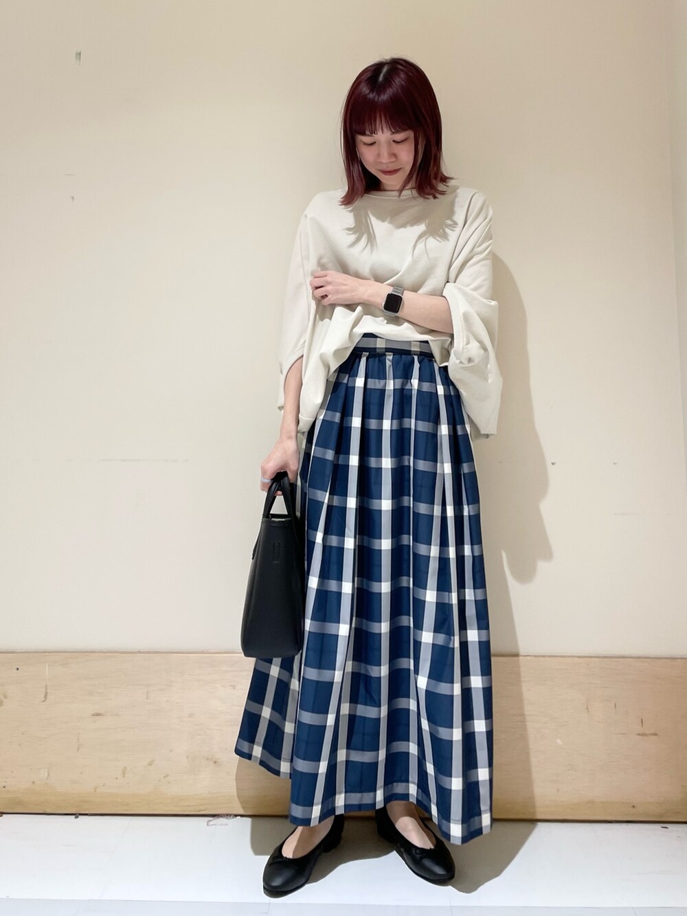 ベージュ系のTシャツ/カットソー、ブルー系のスカート、ブラック系のトートバッグを着用したレディースの春コーディネートの2枚目の写真