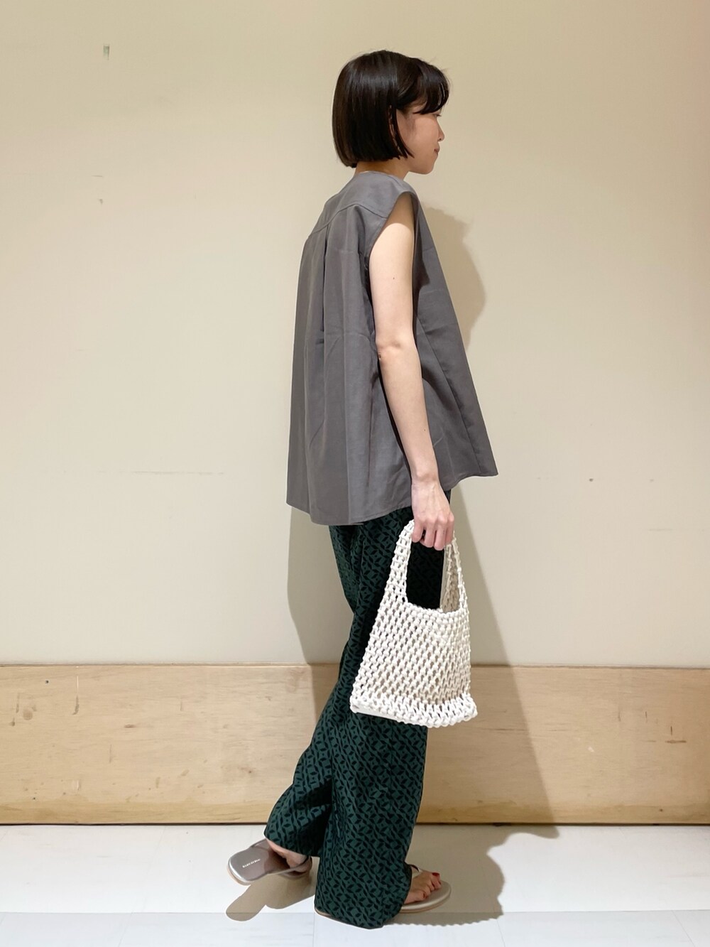 グレー系のシャツ/ブラウス、ホワイト系のハンドバッグ、シルバー系のサンダルを着用したレディースの夏コーディネートの6枚目の写真