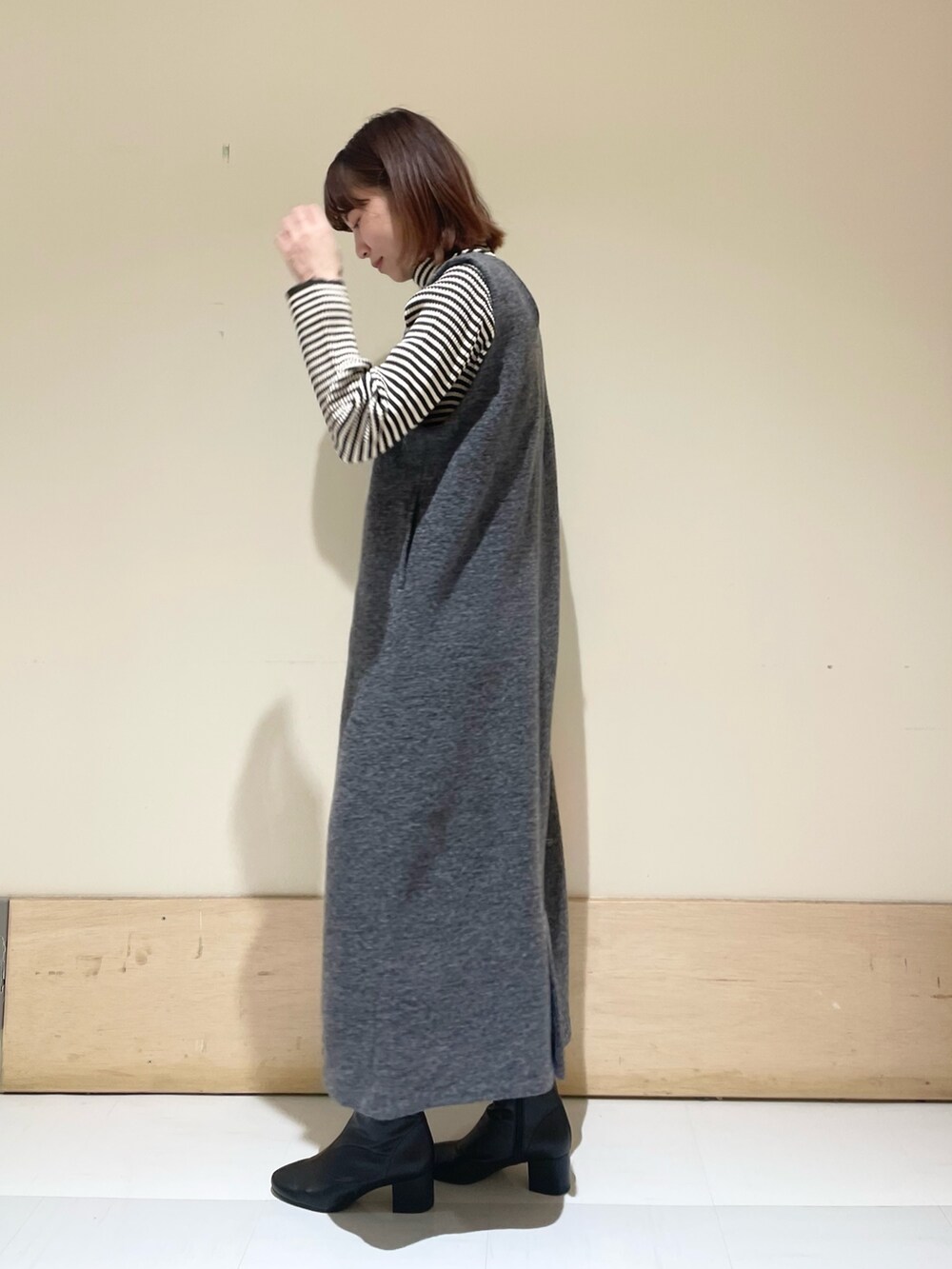 ホワイト系のニット/セーター、グレー系のワンピースを着用したレディースの冬コーディネートの5枚目の写真